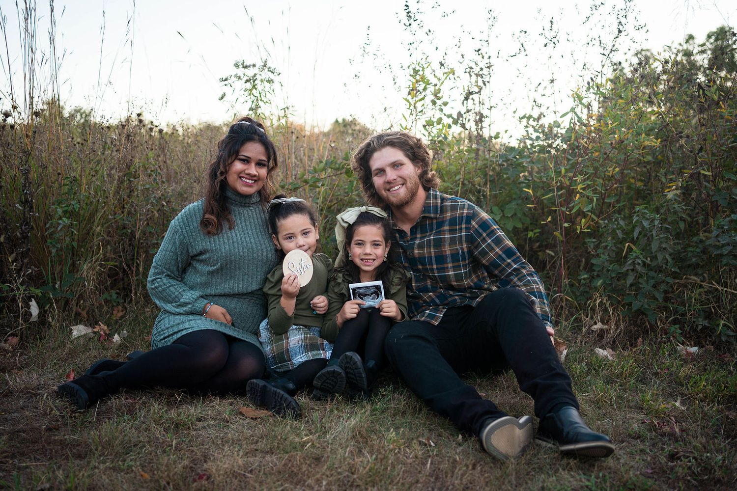 A family announces a pregnancy in the fall in Blue Springs during their maternity and family photo shoot