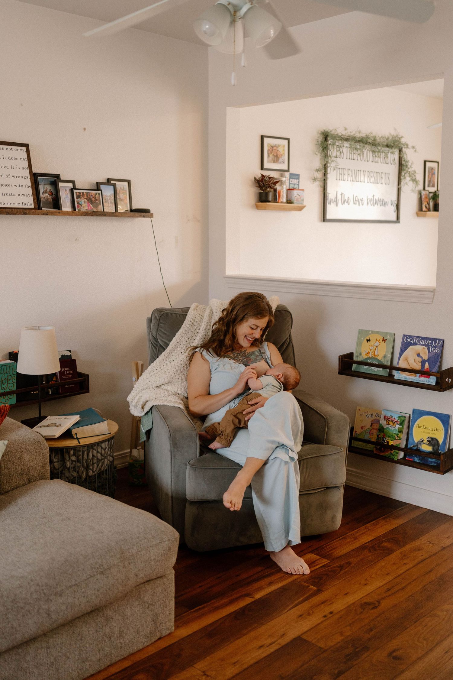 A new mom feeding her baby in their home during their Warrensburg in-home newborn session