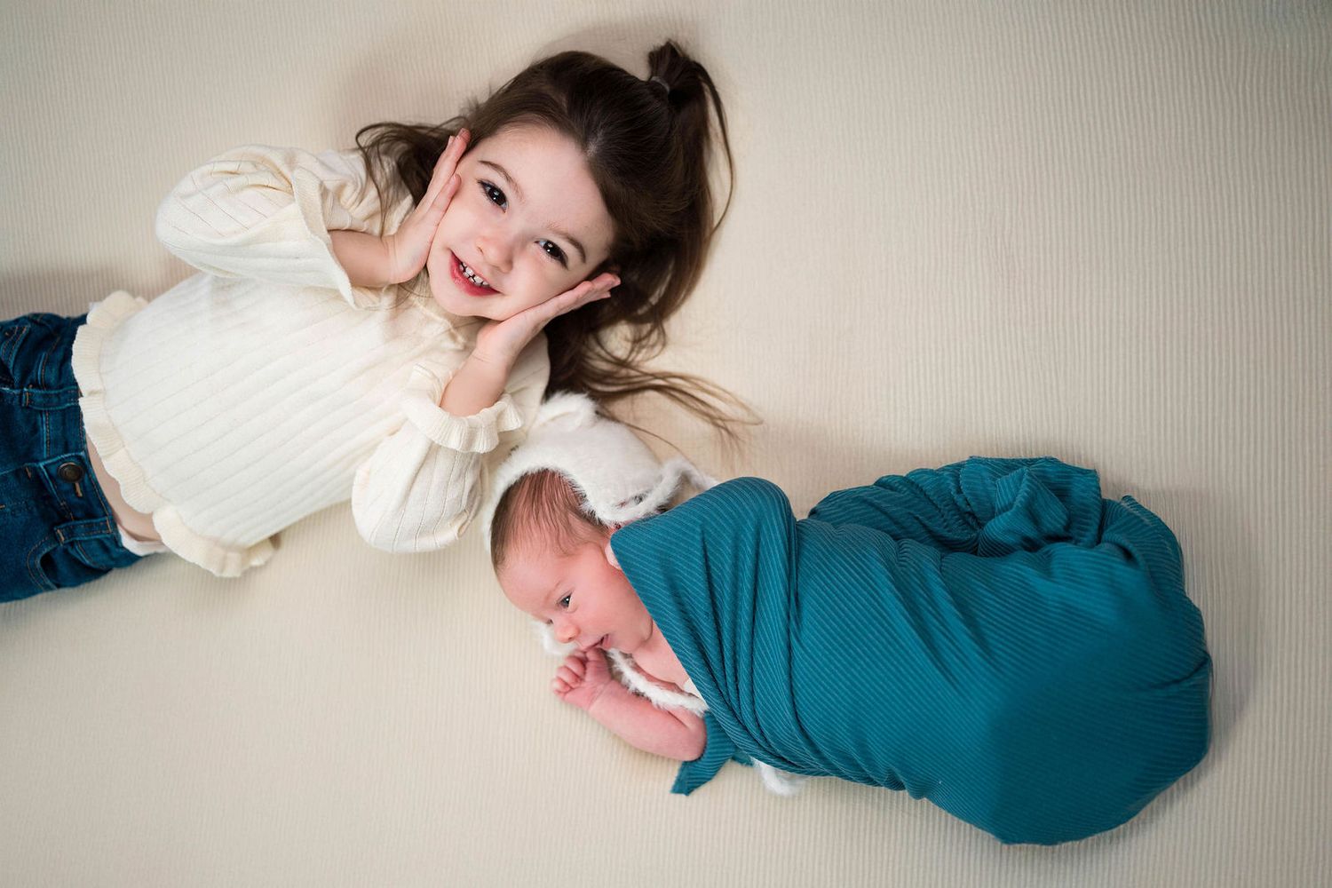 a sister and brother pose during a newborn photoshoot in Warrensburg