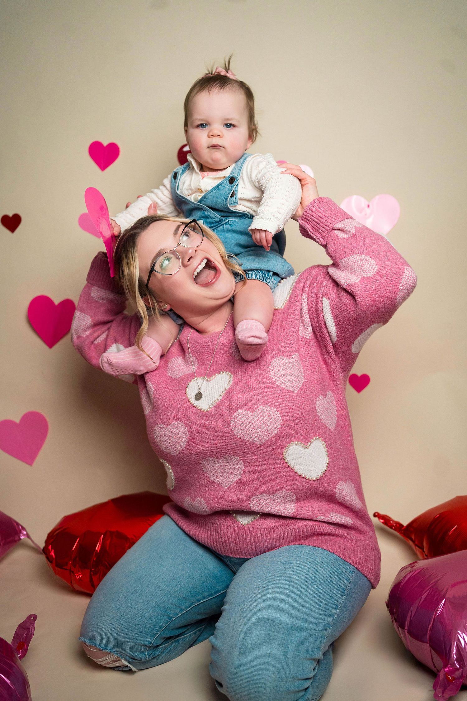 A mom and daughter look at the camera during a holiday mini session in the photographers home in Warrensburg