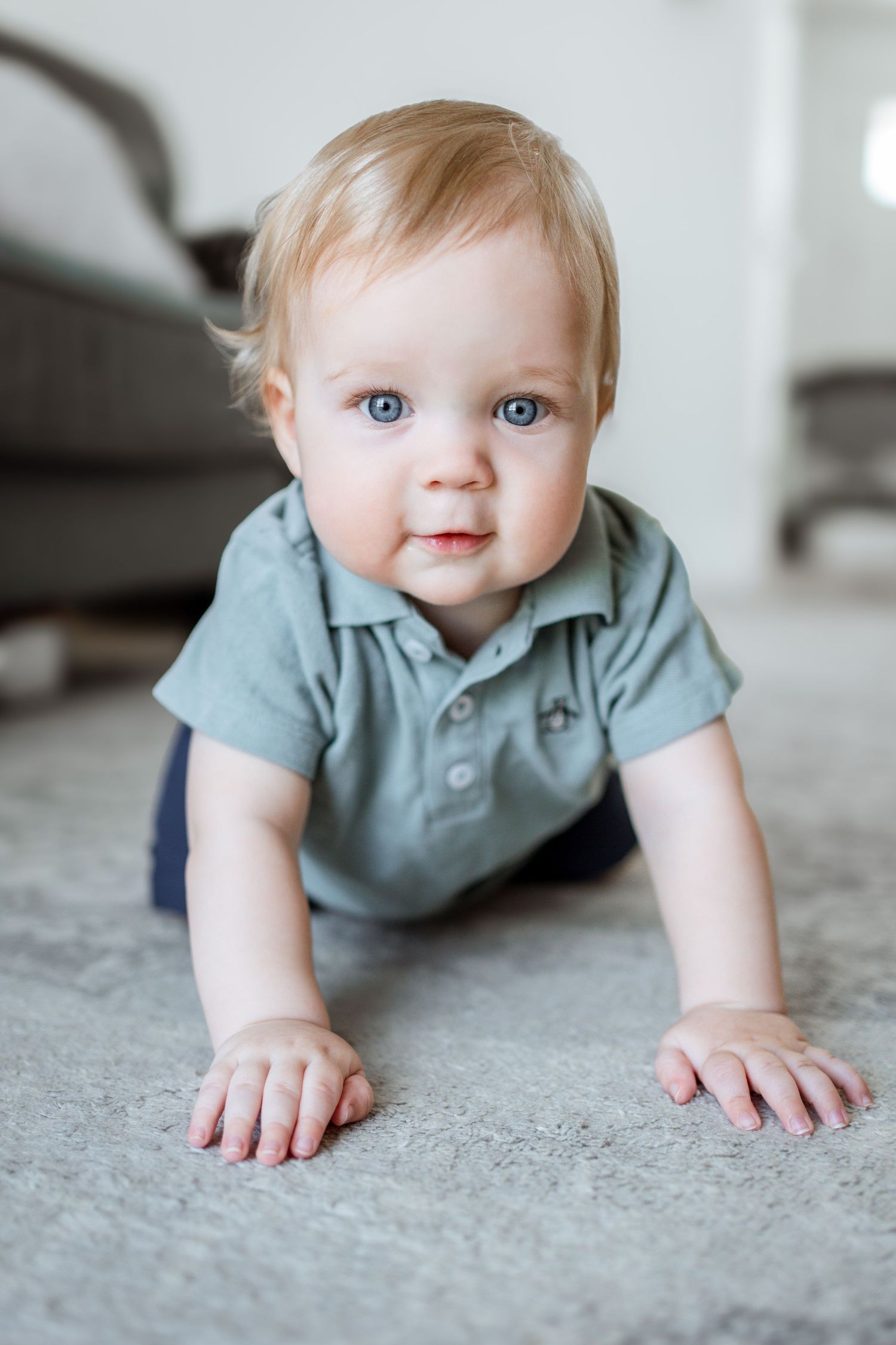 Baby in light blue polo shirt crawls on gray carpet in progressive sequence of close-up photos.