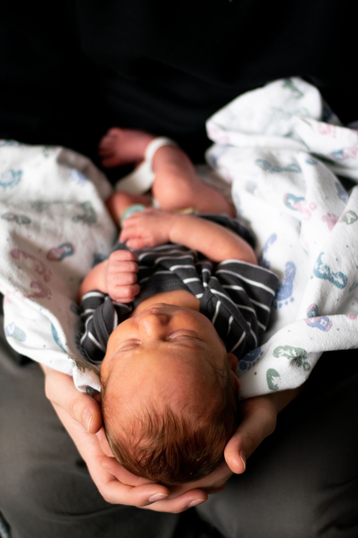 A sleeping newborn baby lies peacefully on dark fabric in a series of connected artistic photographs.