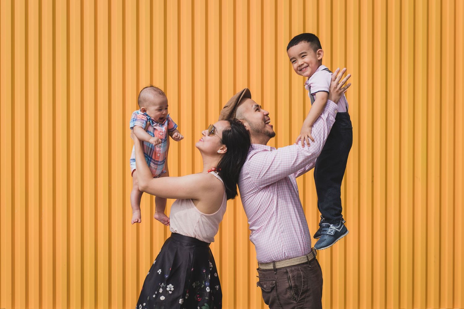 Family having fun against vibrant orange striped wall background.