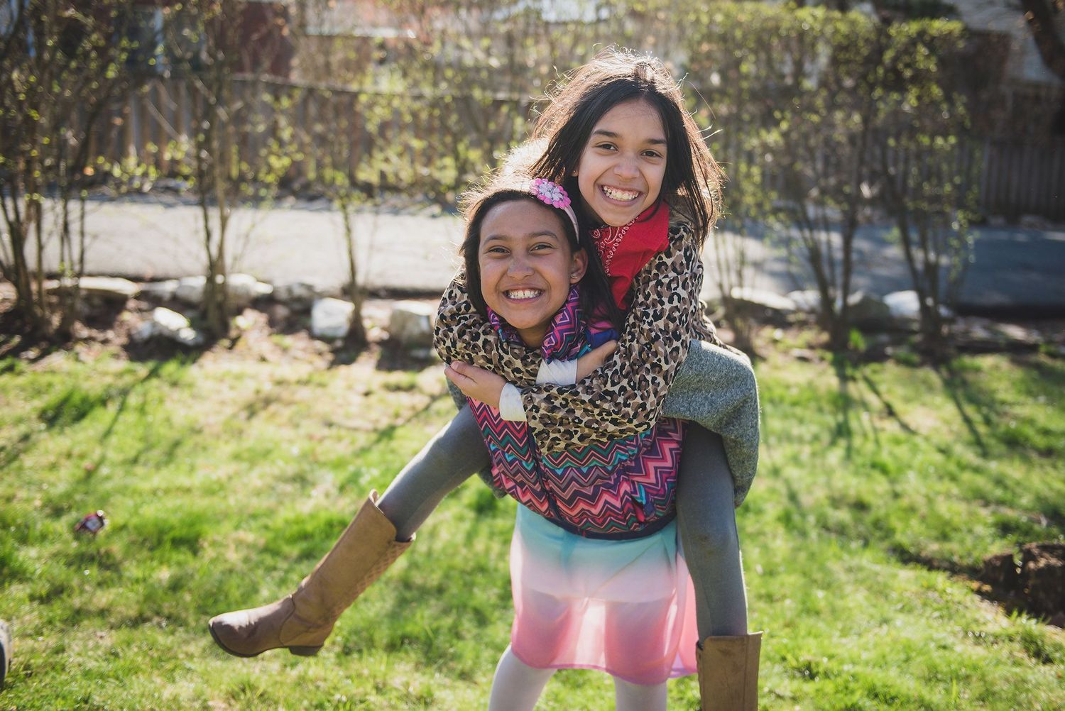 People enjoying playful outdoor photo session in sunny grassy field.