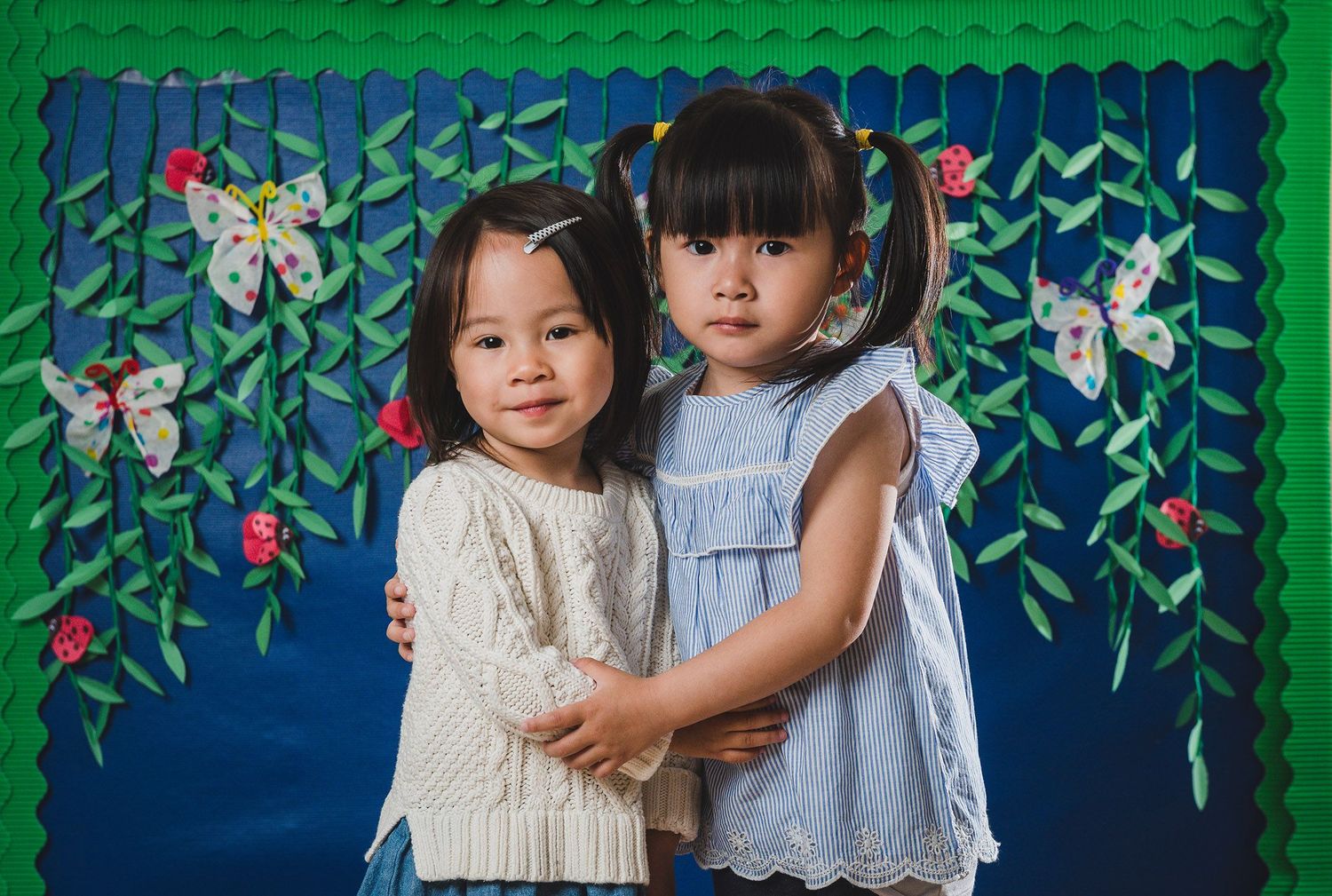 Decorative backdrop featuring painted flowers and vines against blue and green background.