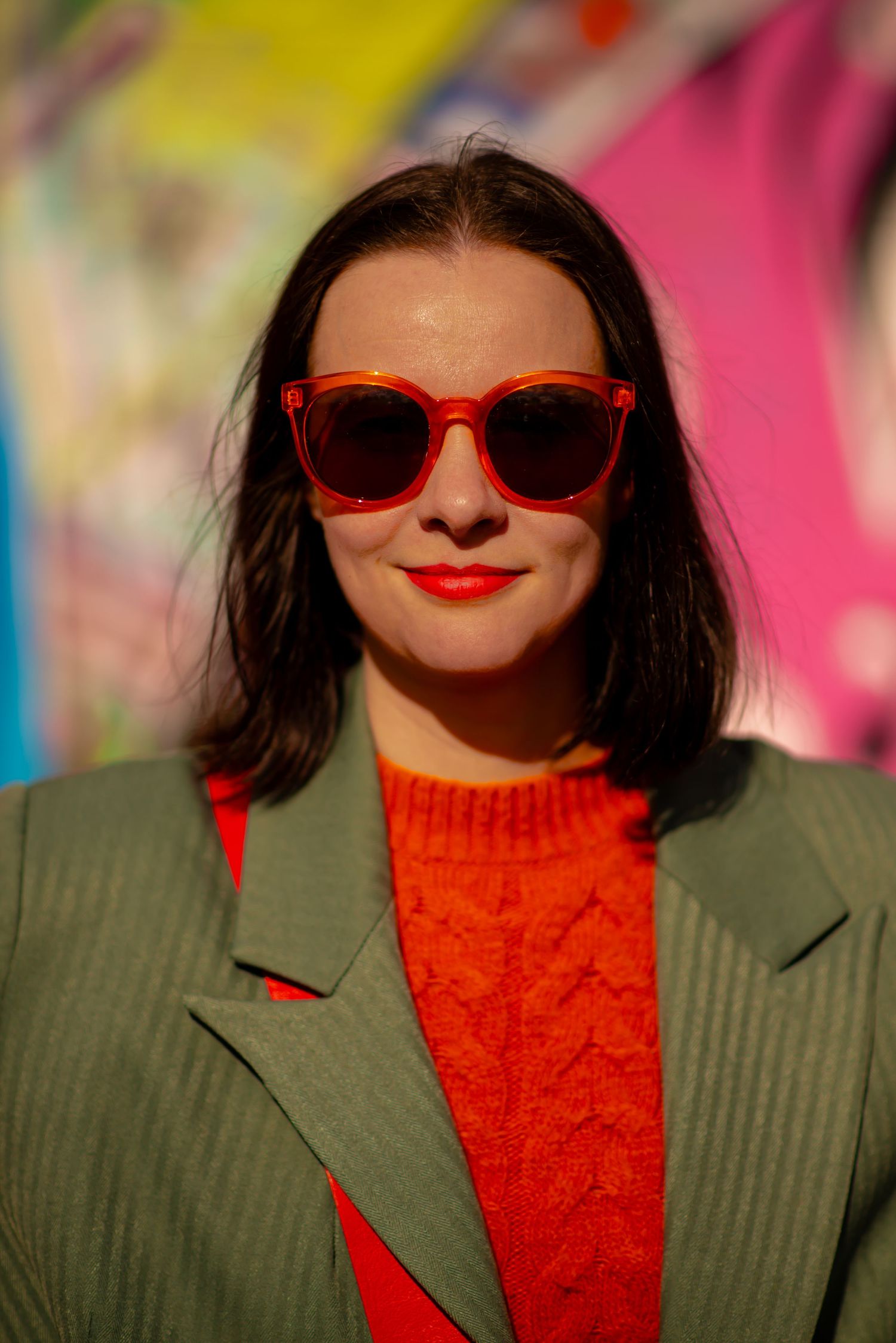 Glasgow creative portrait of a woman in her thirties with shoulder length black hair in front of a wall of colourful graffiti