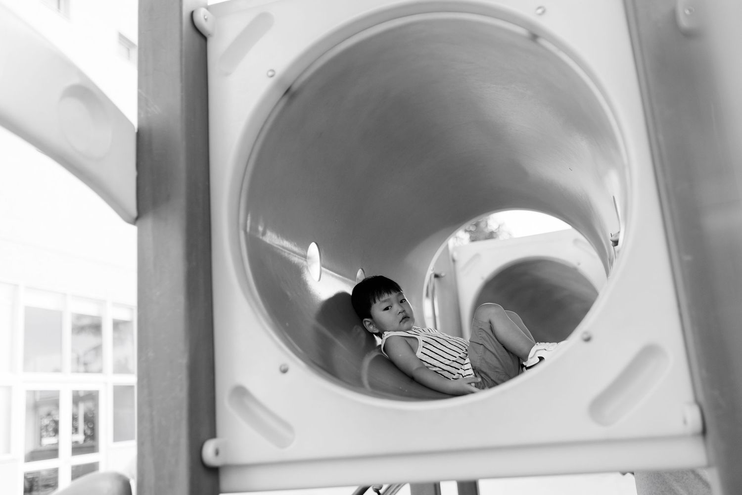 A series of black and white images showing someone peeking through circular openings.