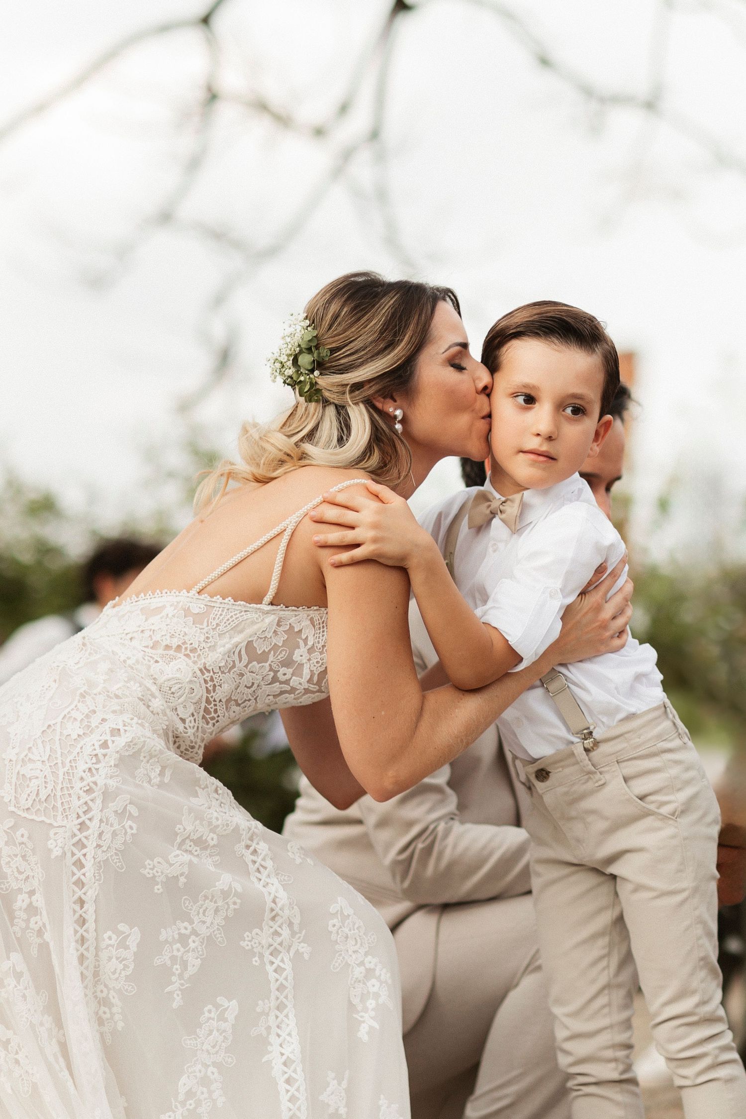 Sweet wedding day moments with a young ring bearer in matching beige attire.