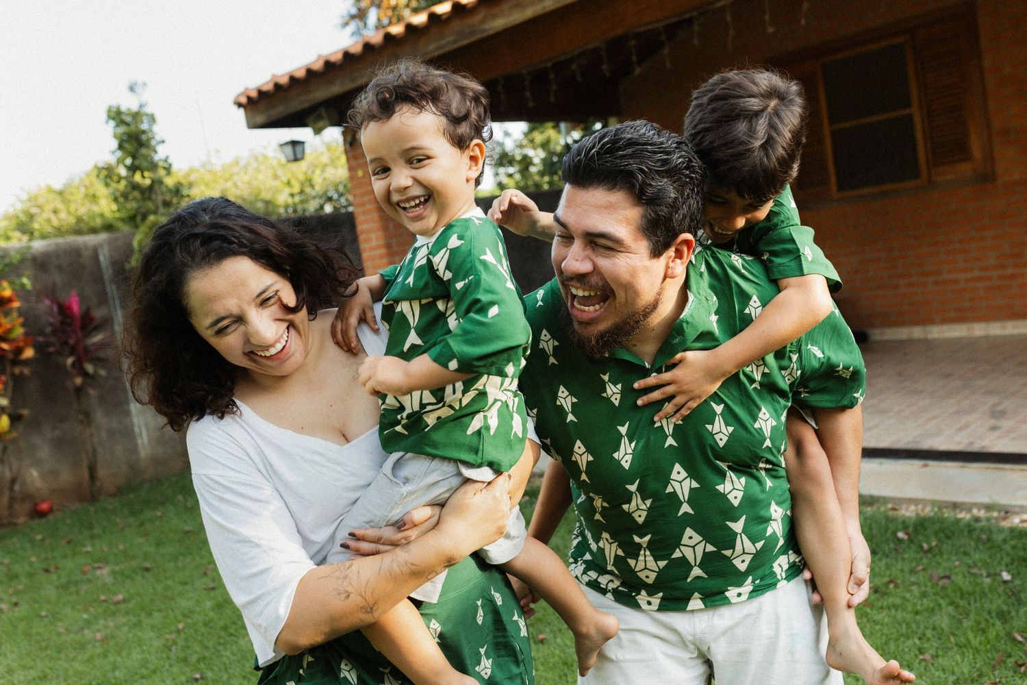 A couple in green and white outfits share joyful moments together in a backyard setting.