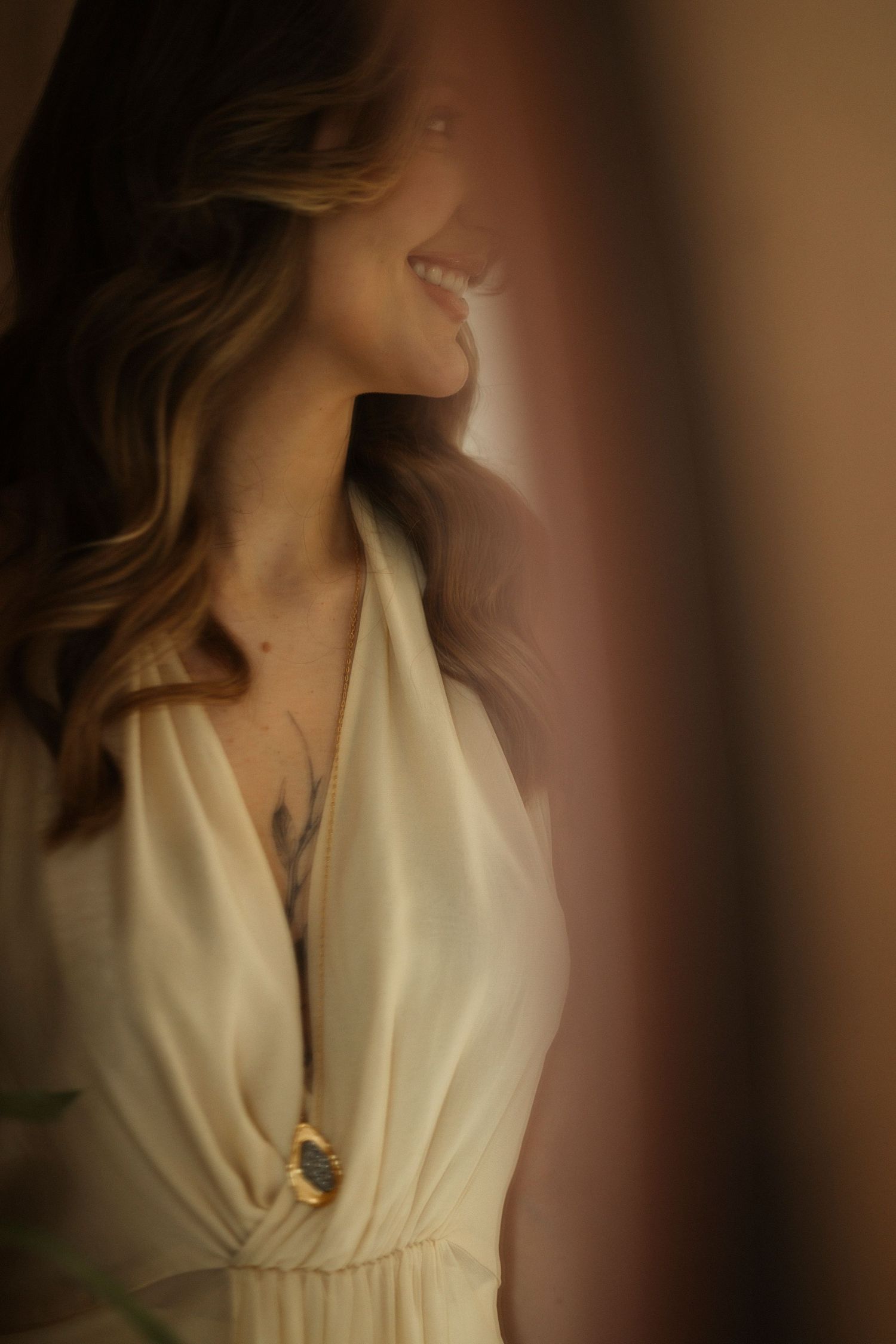 Close-up details of a cream colored dress with delicate neckline.