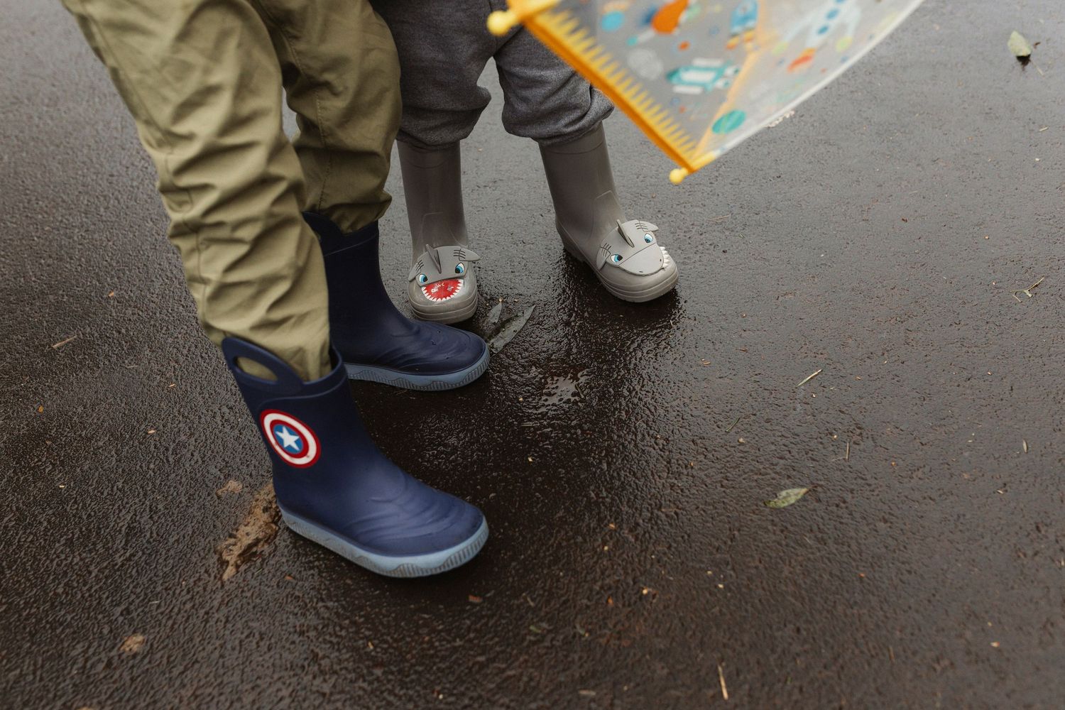 Feet walking through puddles on wet pavement with reflections.