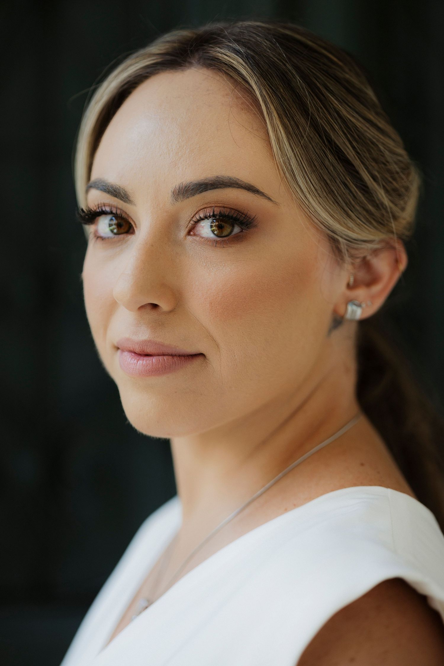 Close-up portrait shot showing elegant bridal makeup and jewelry.