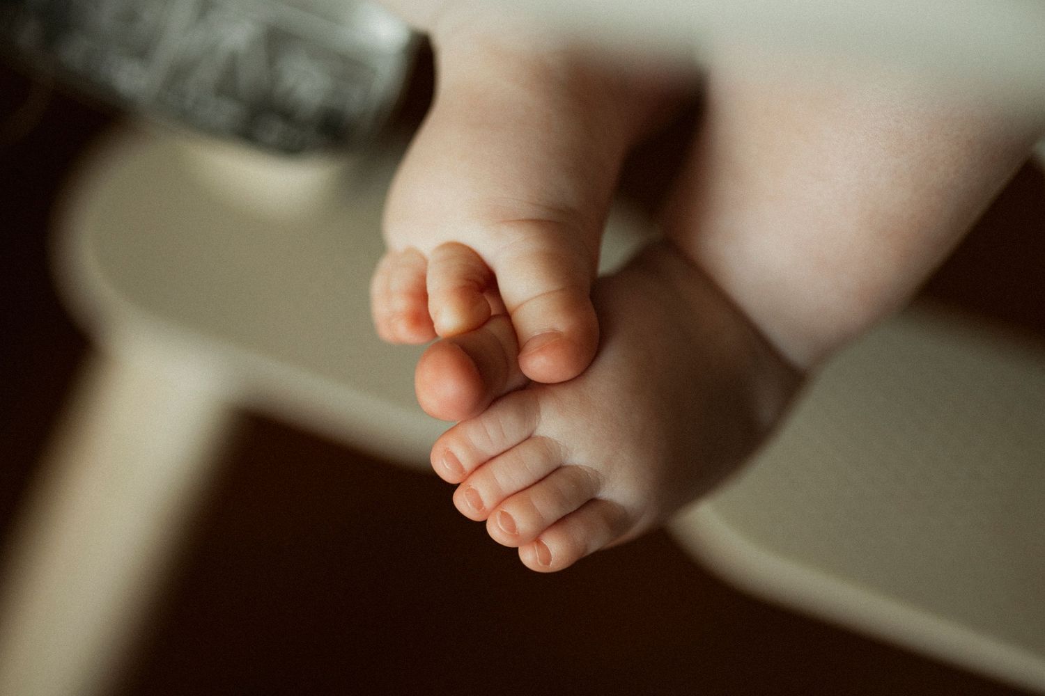 Close-up of tiny newborn baby feet and toes, soft skin detail photography.