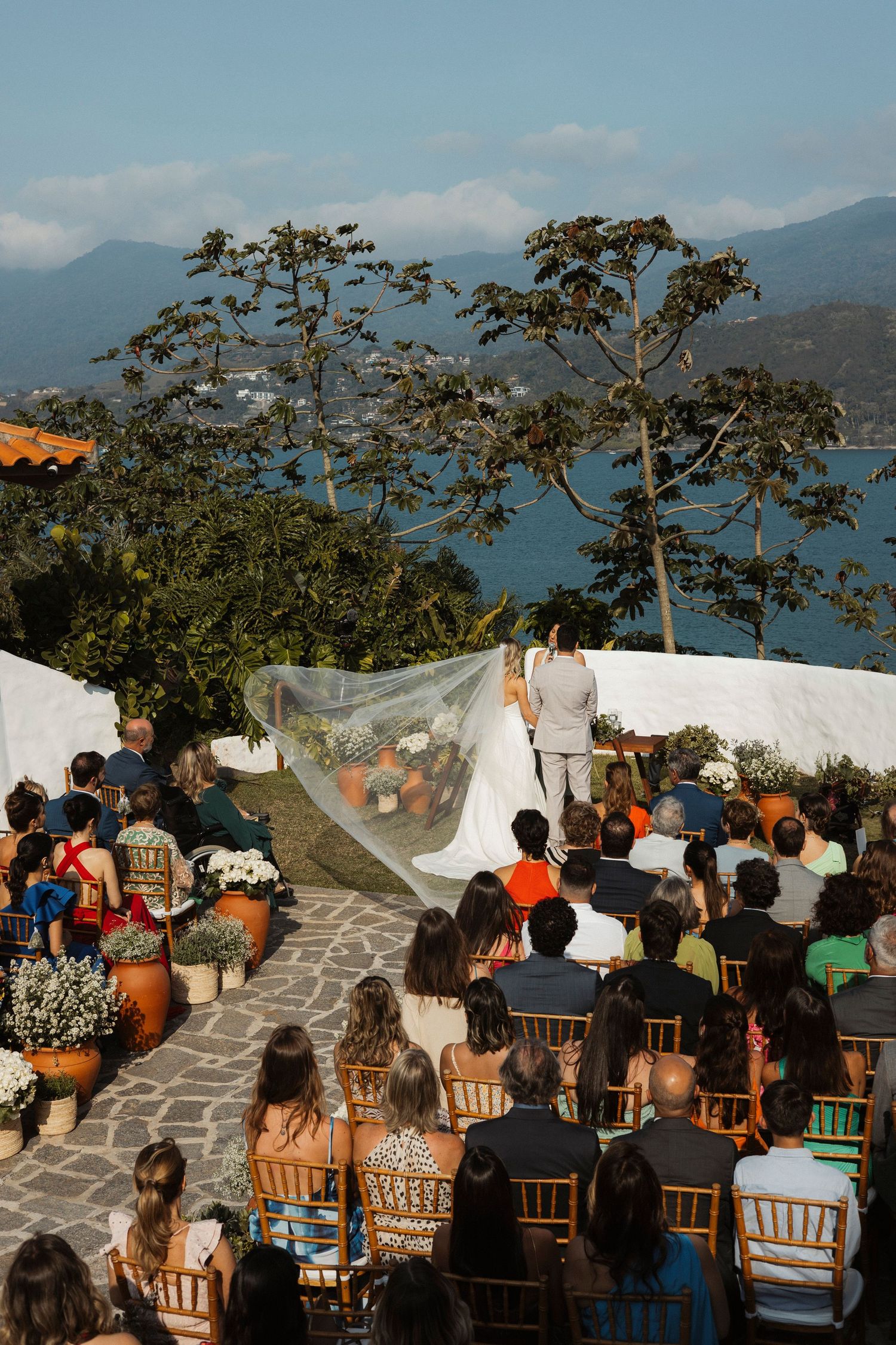 Wedding ceremony setup with guests seated overlooking a scenic ocean view.