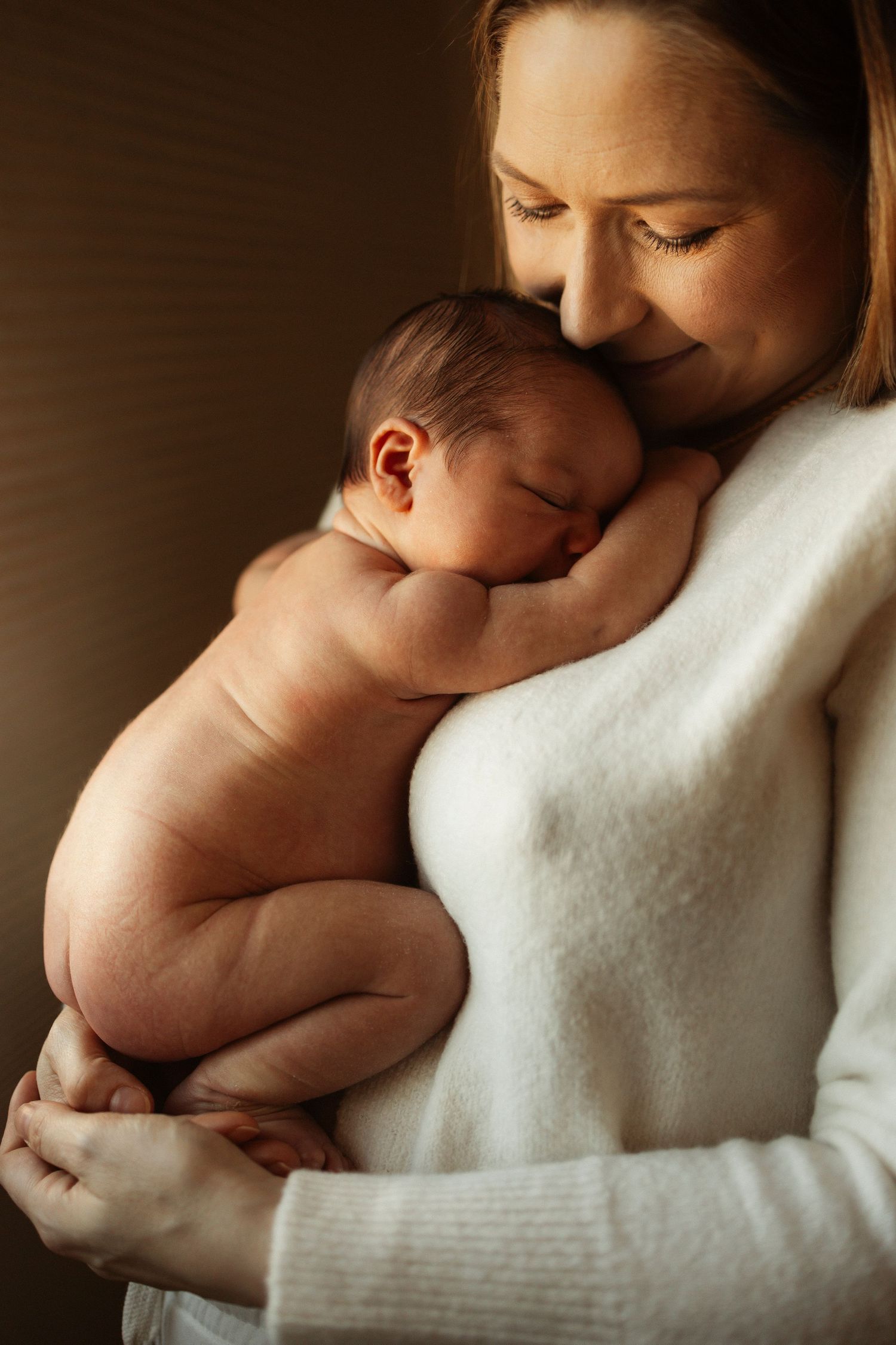 Tender moments of a baby resting against a soft white sweater.