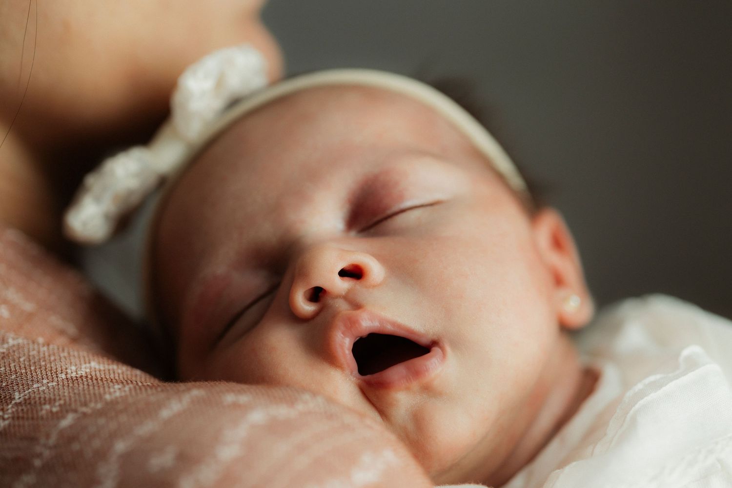 Close-up profile views of a sleeping infant in soft lighting.