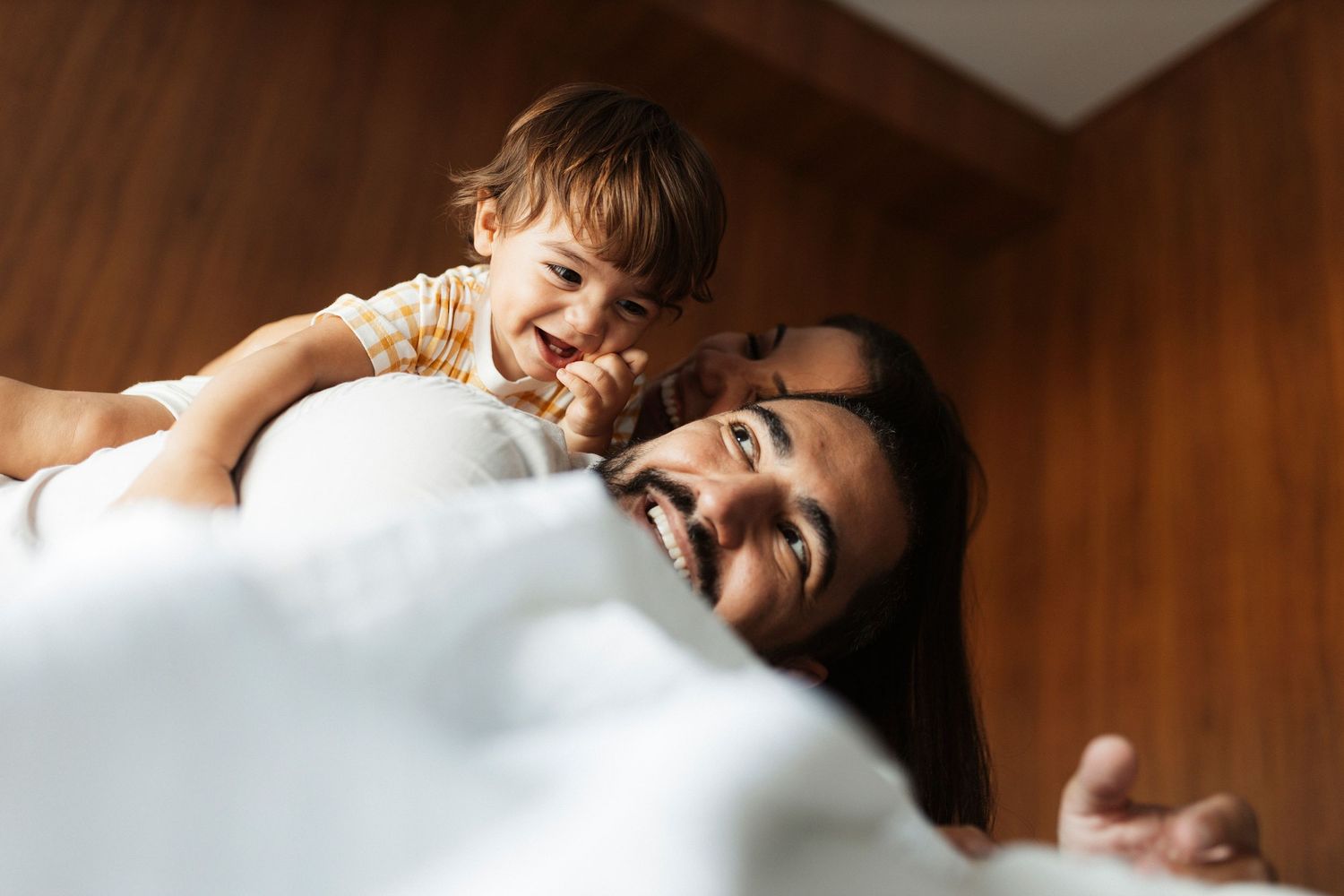 Intimate family moments captured in warm tones showing joyful connection and laughter.