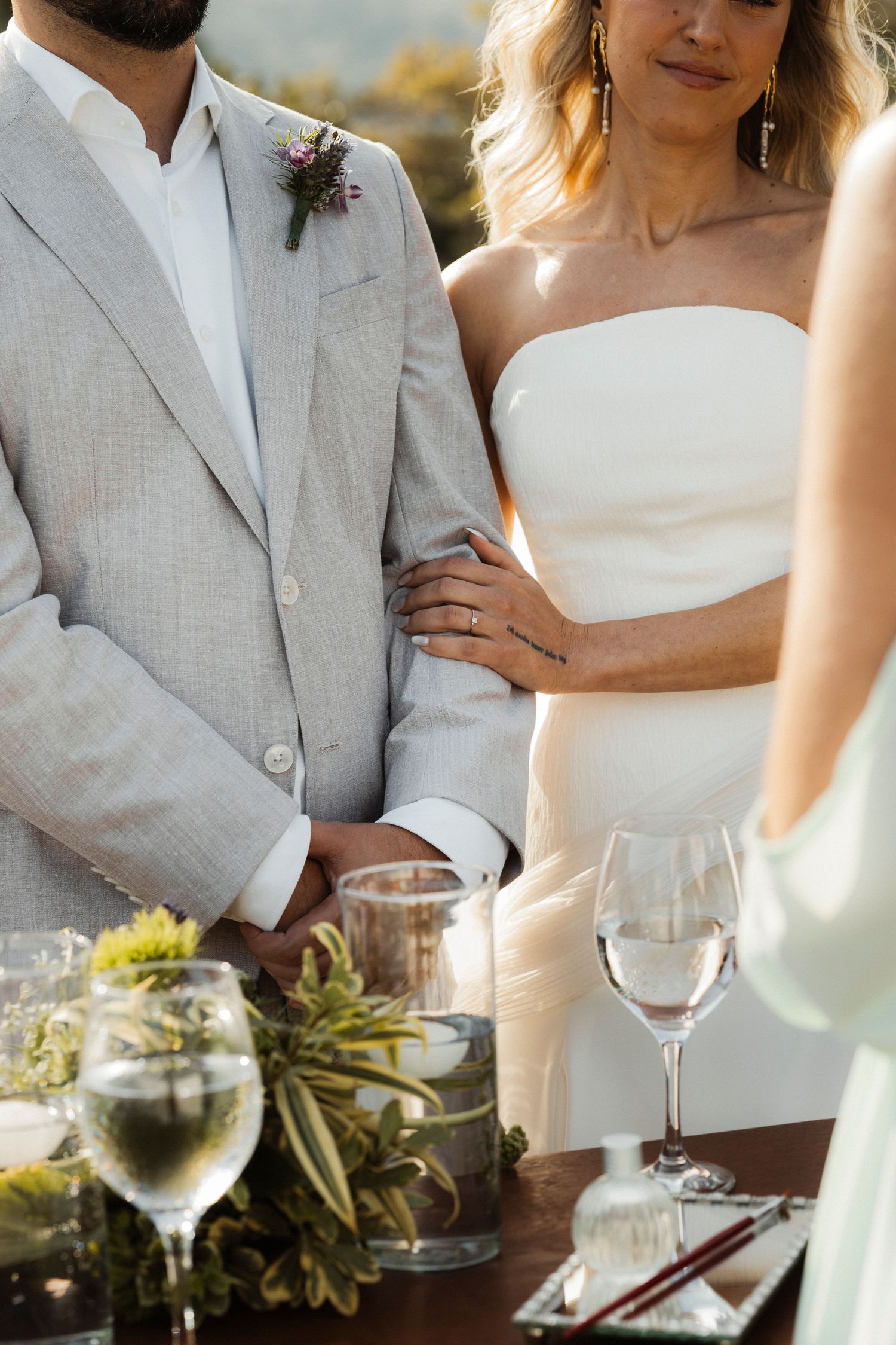 Wedding table setting with wine glasses and floral arrangements in natural lighting.