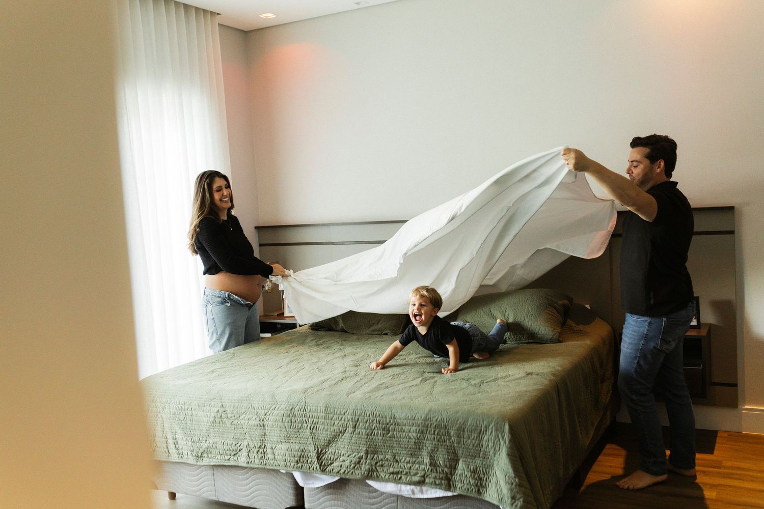 A sequence of photos shows a person laying on a bed and being covered by a floating white sheet.