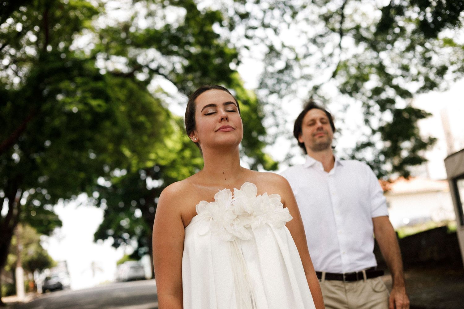 A couple shares an intimate moment against a natural outdoor backdrop.
