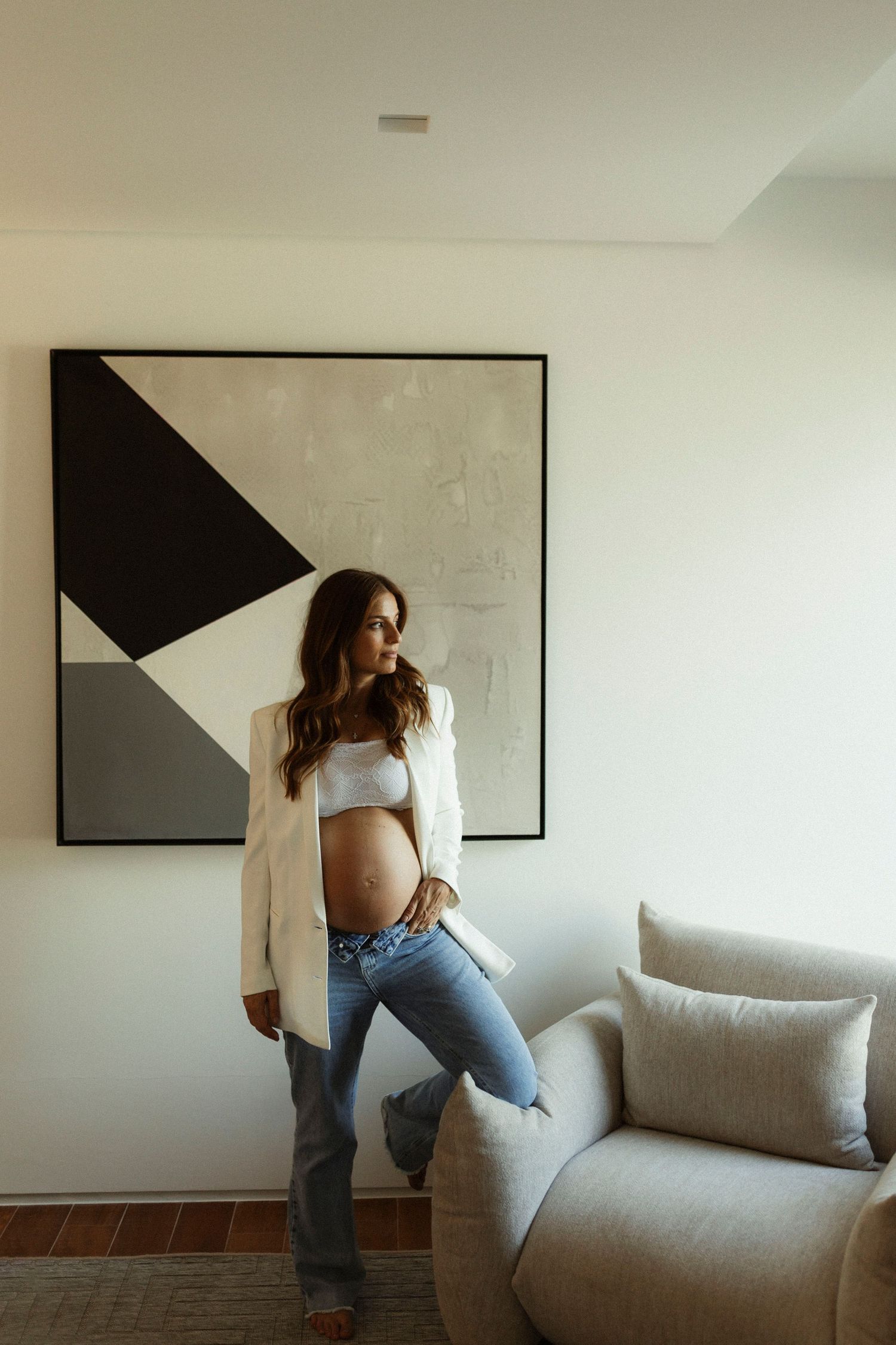 Person in casual wear interacting playfully with a light gray couch in sequence.