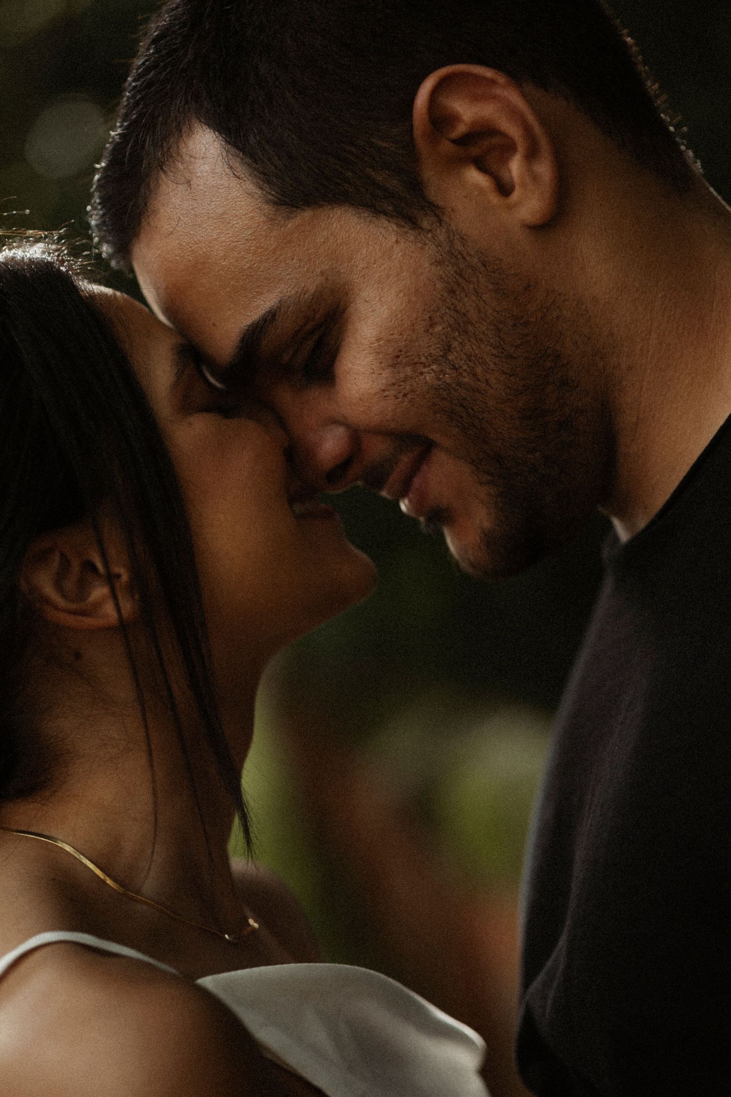 Intimate close-up portraits of a couple in soft natural lighting.