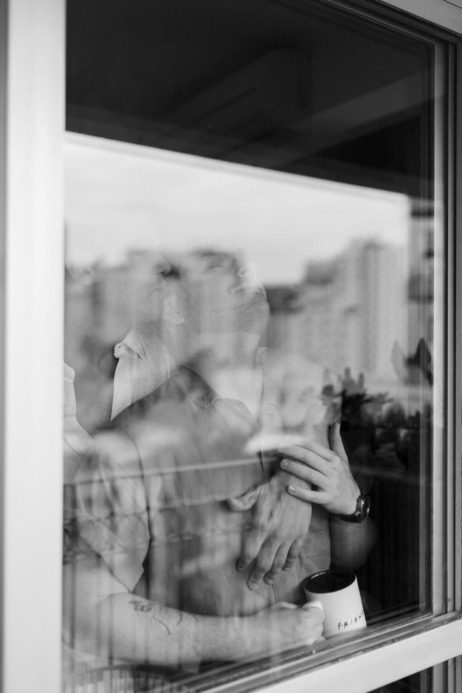 Reflections and shadows visible through a large window pane.
