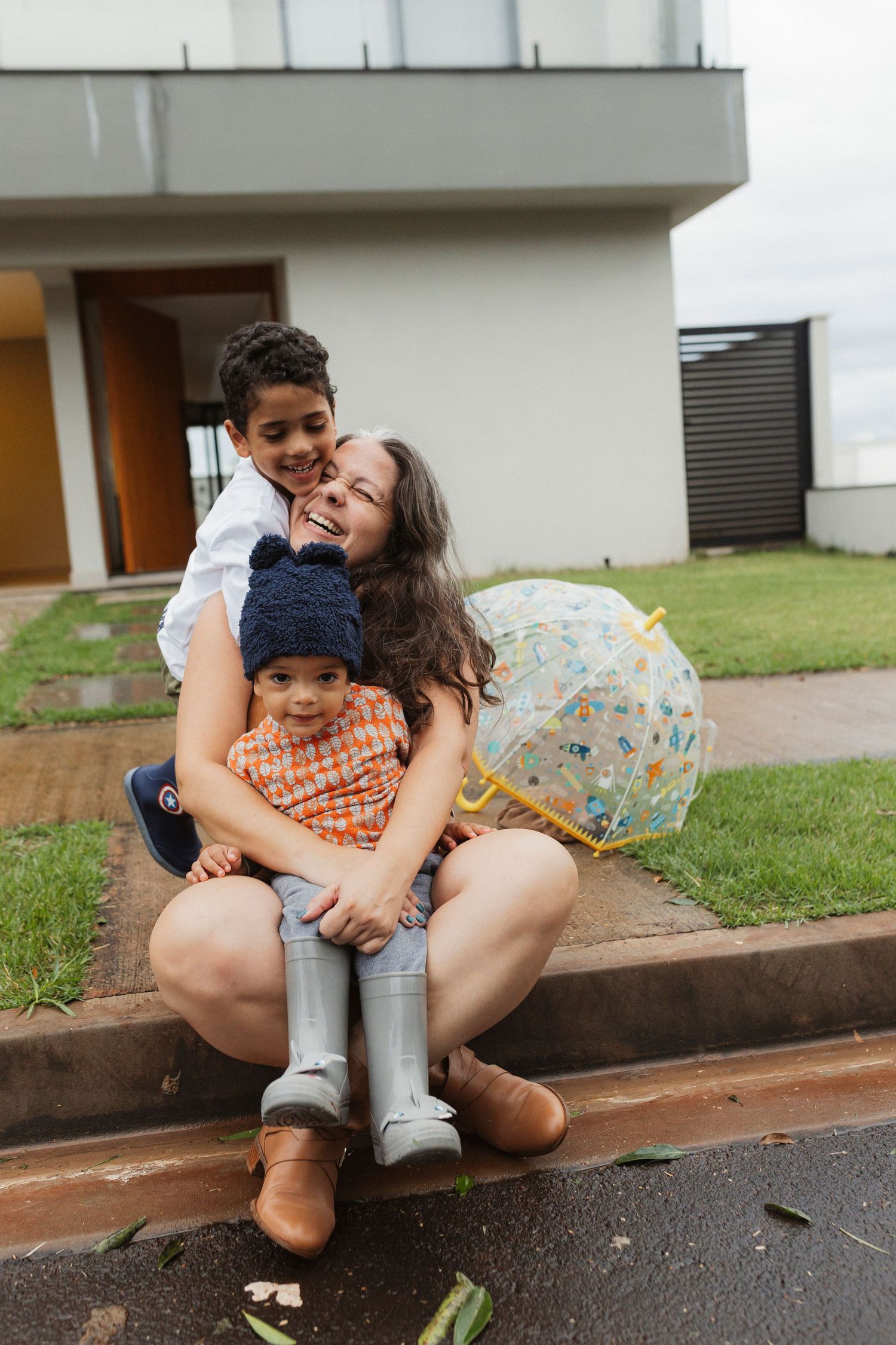 Playful moments captured on a grassy curb outside a modern building.