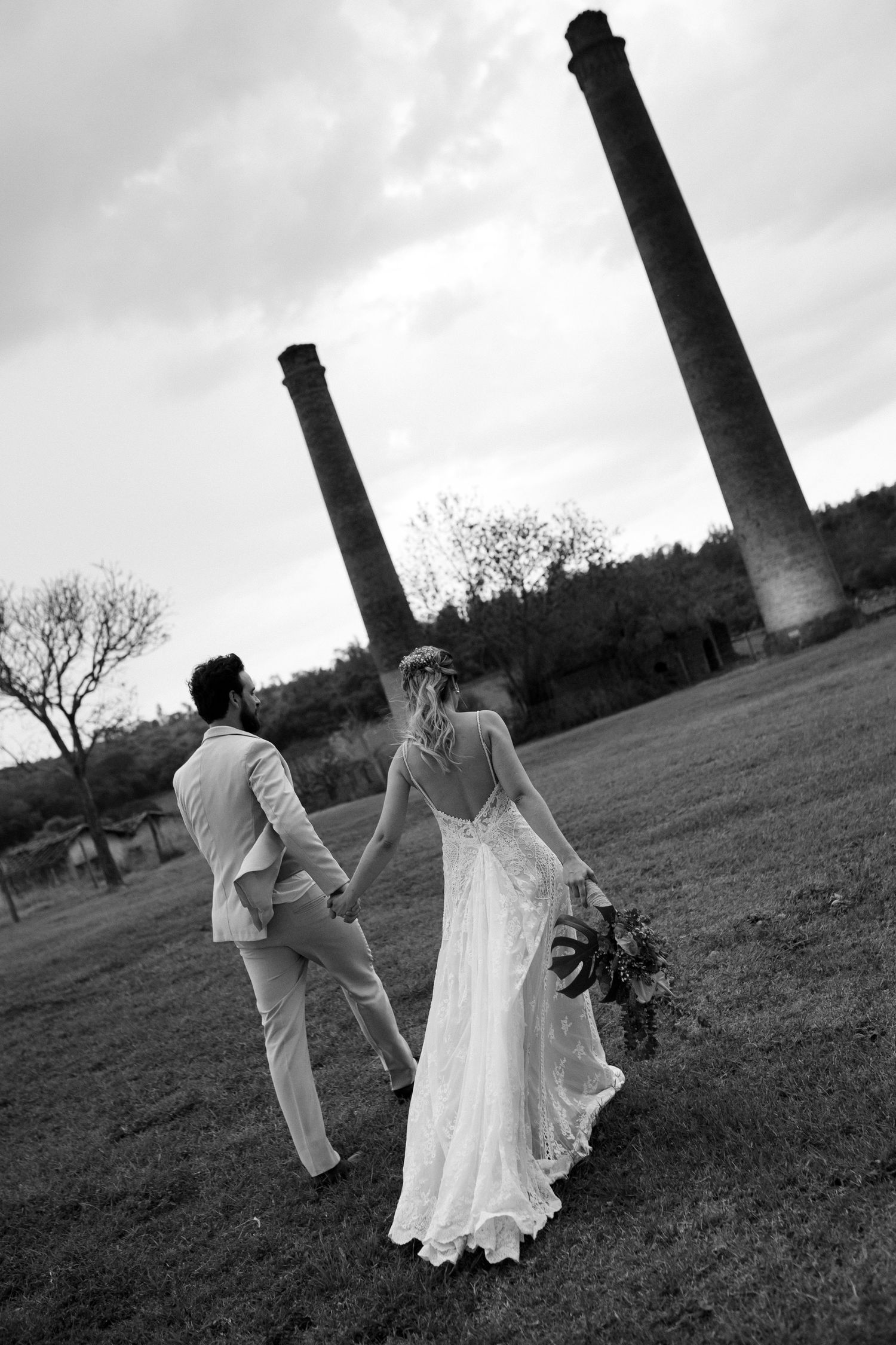Black and white artistic sequence of a couple dancing in an outdoor field with dramatic lighting.