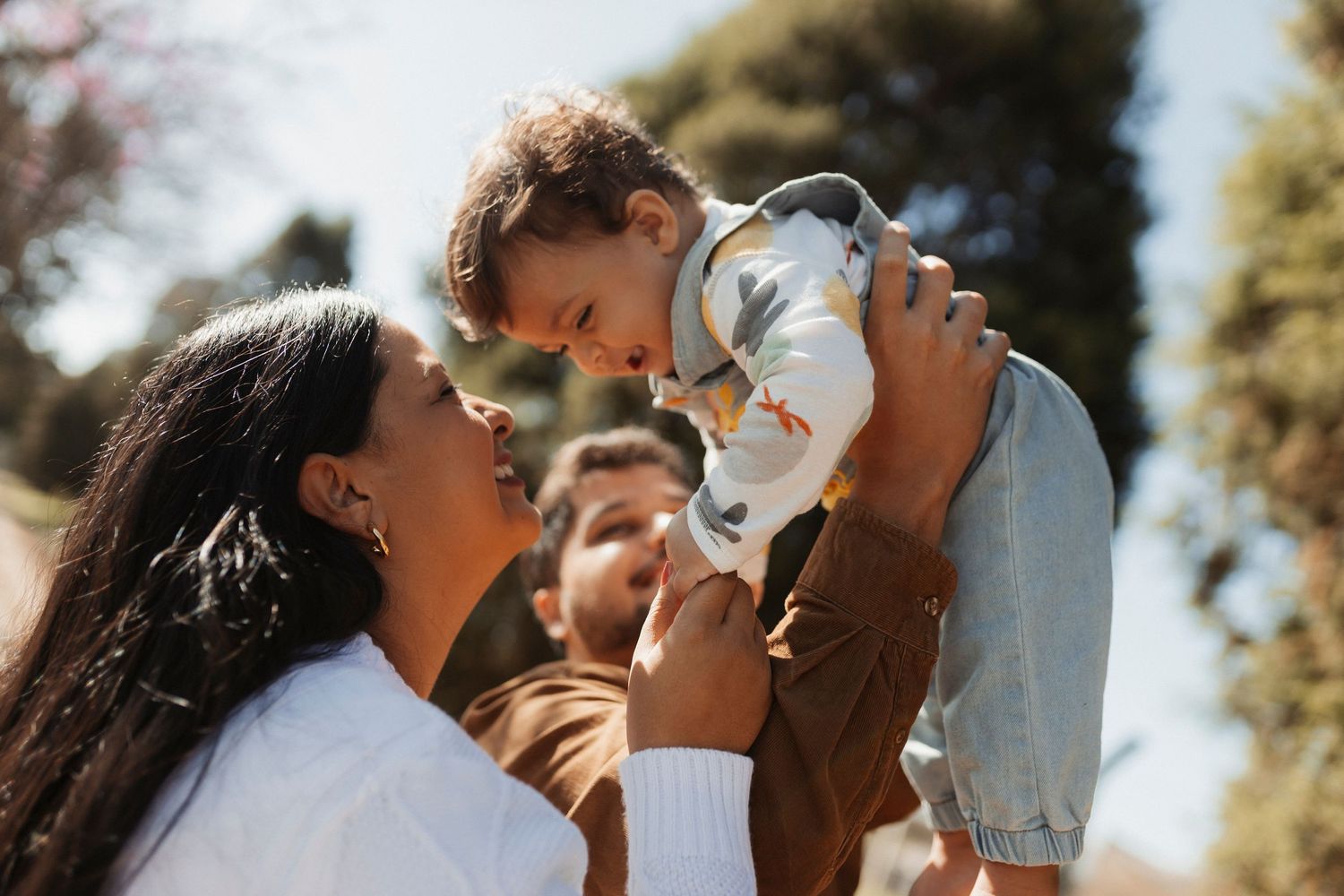 Family sharing joyful moments outdoors on sunny day.