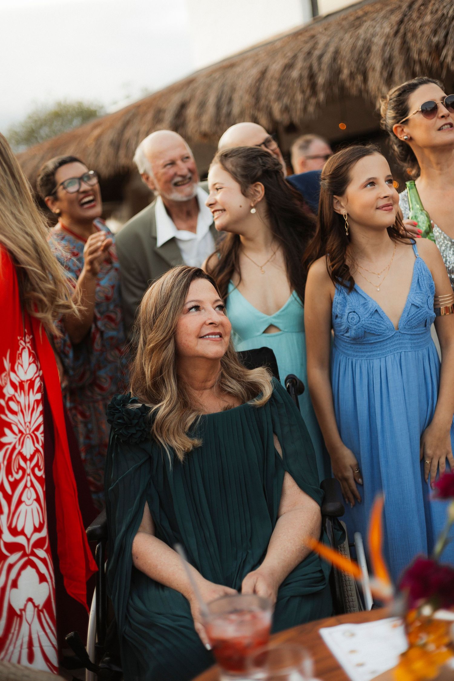 Wedding guests in colorful dresses gather and socialize at an outdoor celebration.
