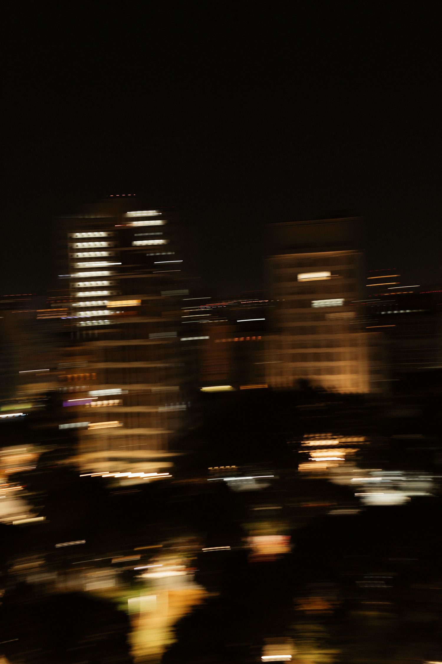 Blurred city lights at night creating abstract patterns of illuminated buildings.