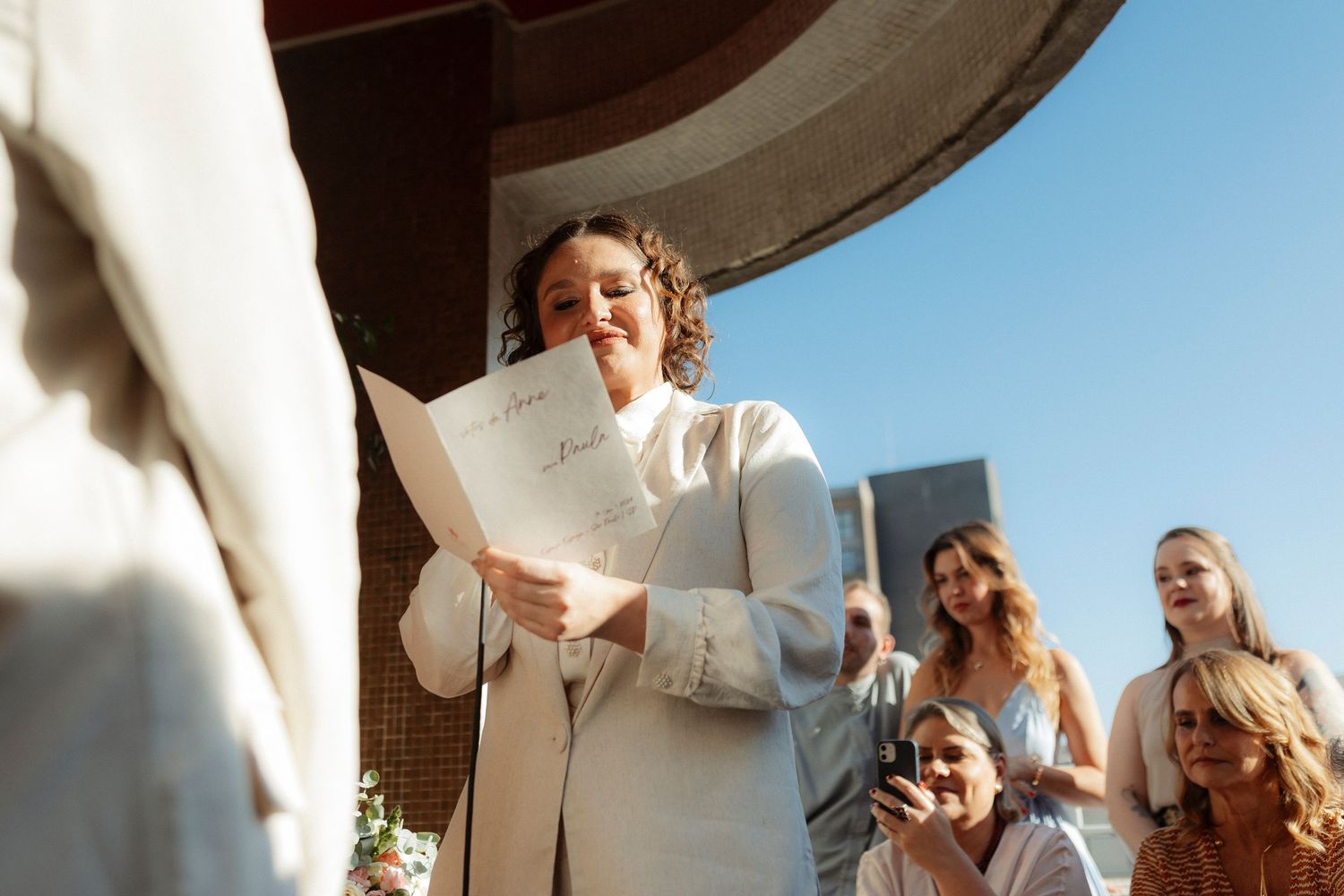 People gathered outdoors under bright sunlight for a celebratory event.