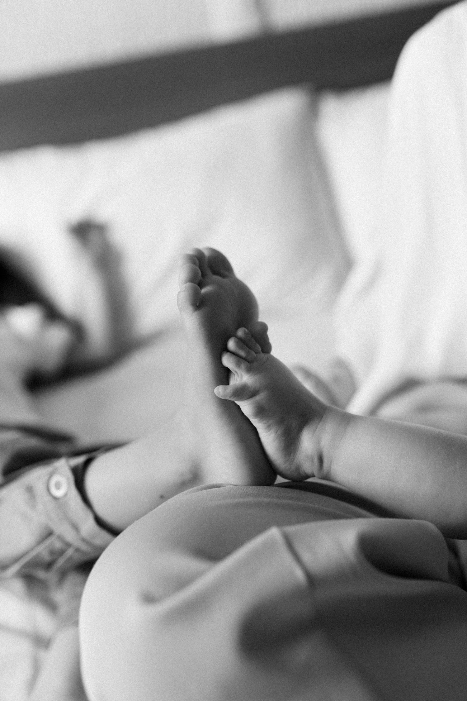 Artistic black and white detail shot of small hands reaching upward.