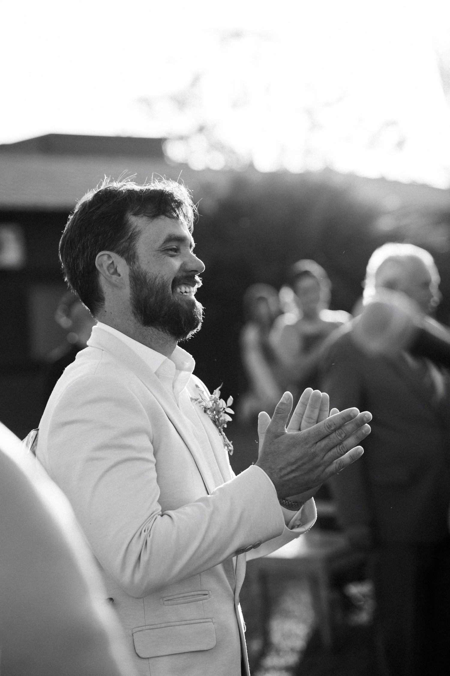 Black and white candid shots of person in white suit clapping and celebrating.