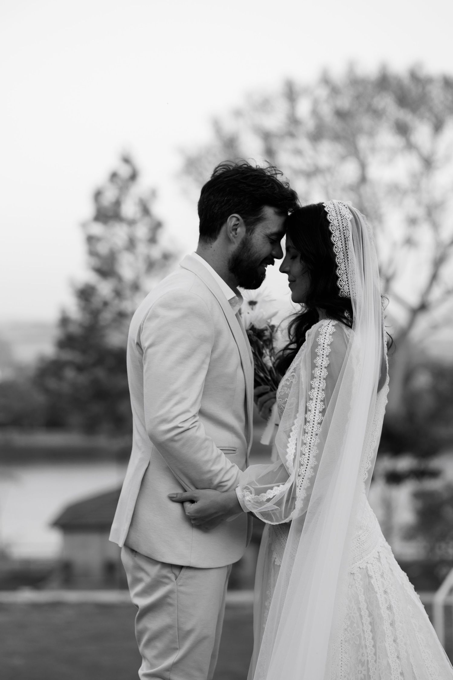 Romantic black and white portrait of newlyweds sharing intimate moment.