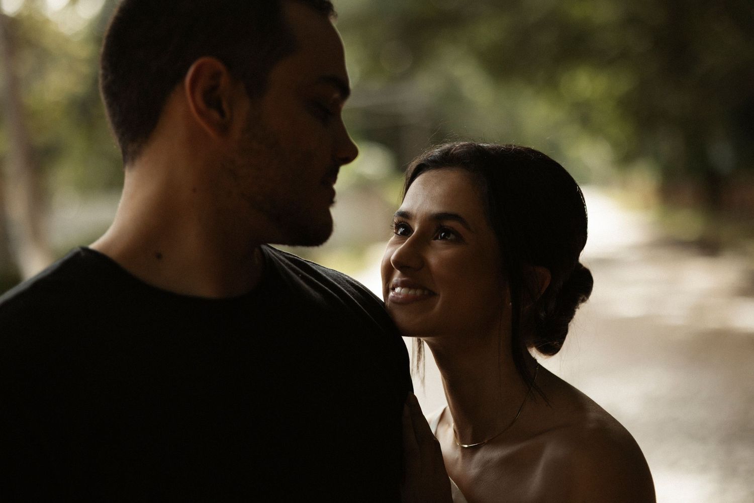 Silhouetted profile views of a couple in an intimate outdoor photoshoot.