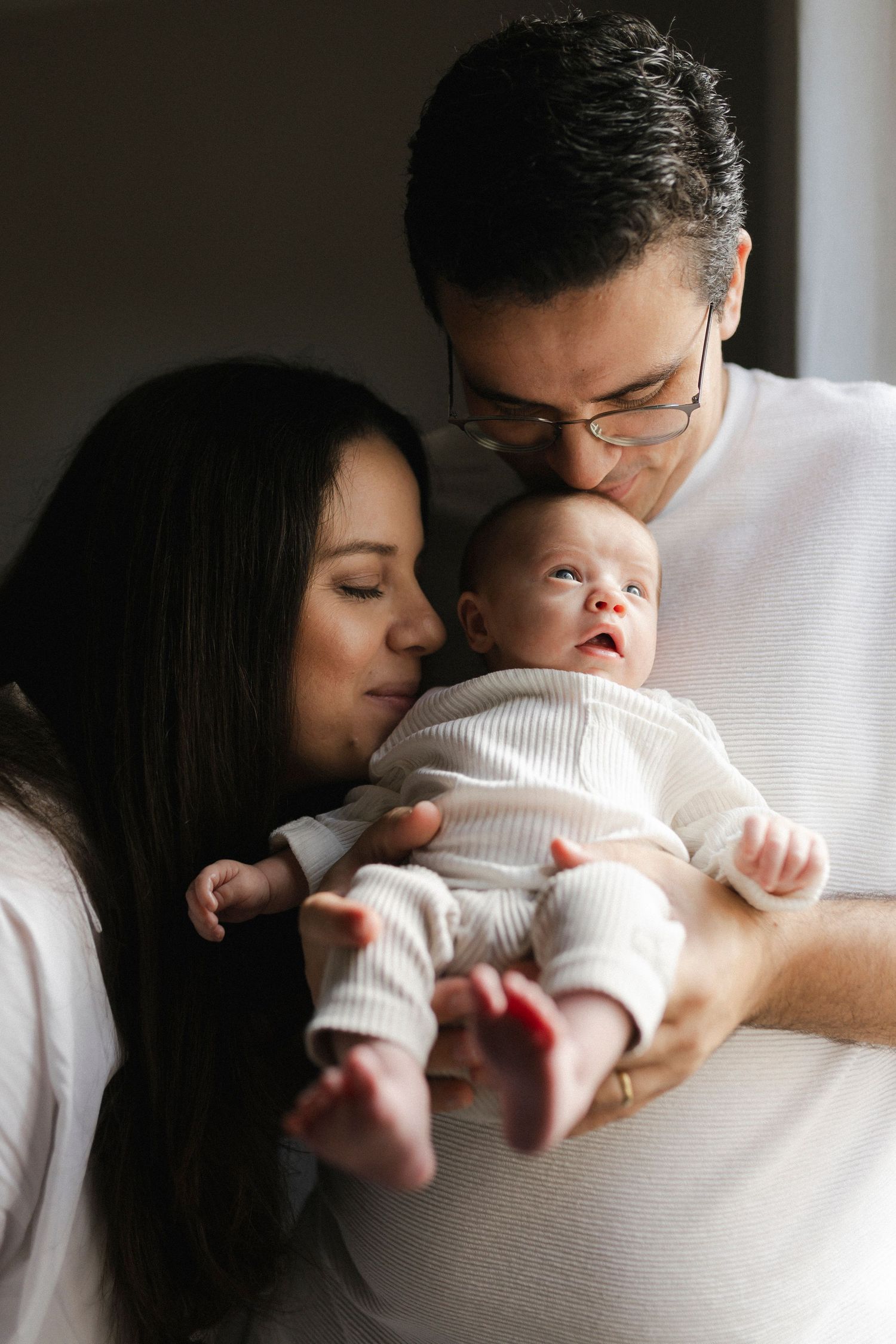 Intimate family moments captured in soft natural window light.
