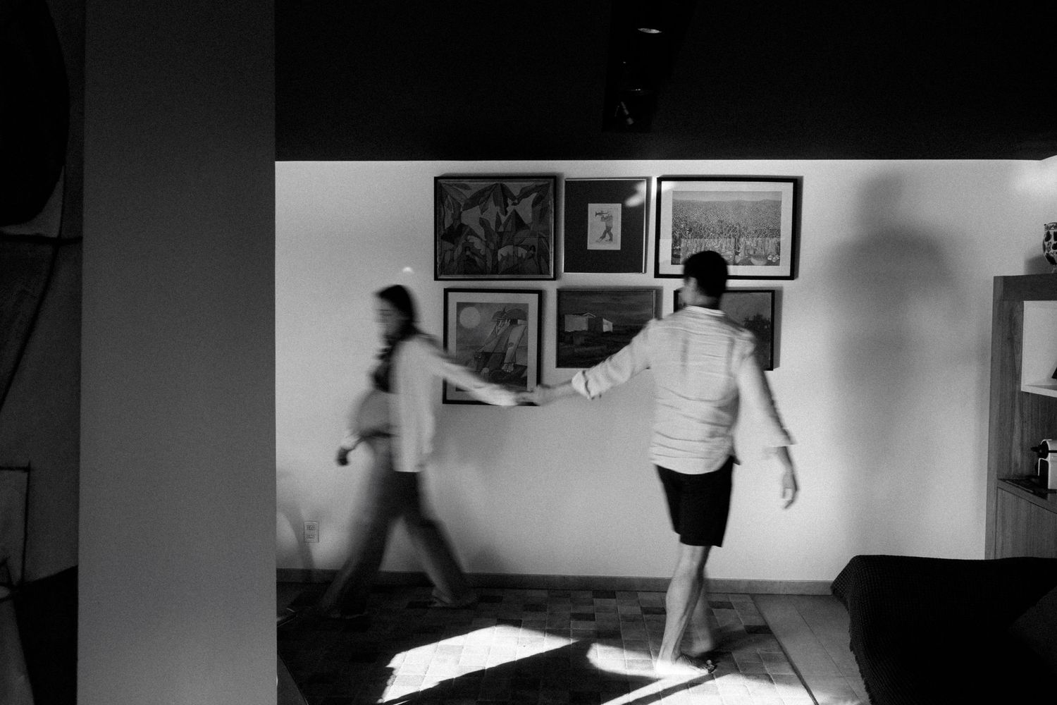 Black and white sequence showing movement and interaction in an indoor setting.