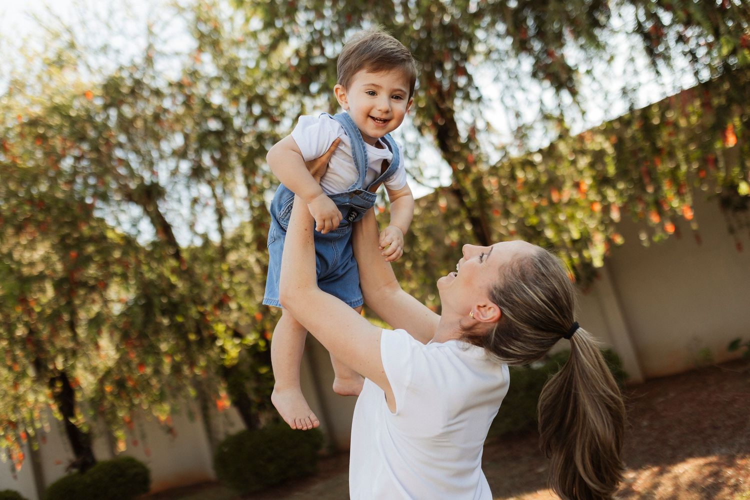 Joyful outdoor playtime captured in warm sunlight beneath autumn trees.