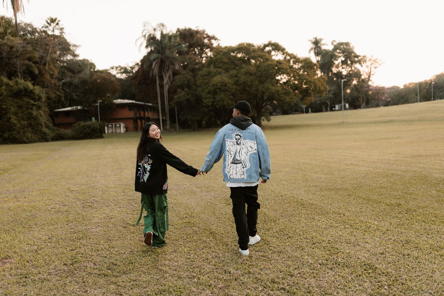 People walking together across a wide grassy field on an autumn day.
