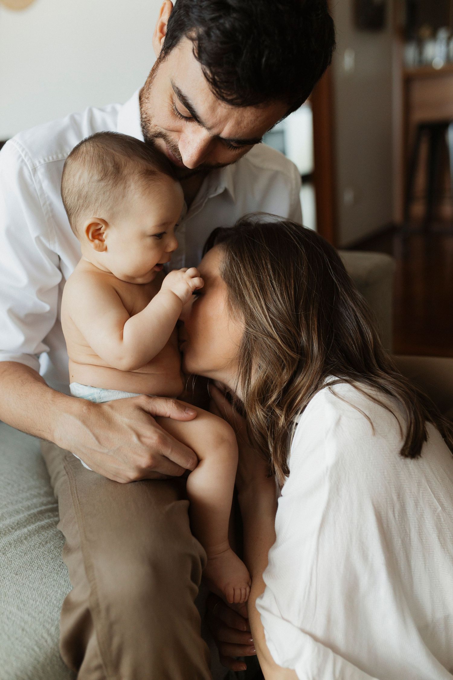 Intimate family portrait series showing loving embraces and gentle kisses.