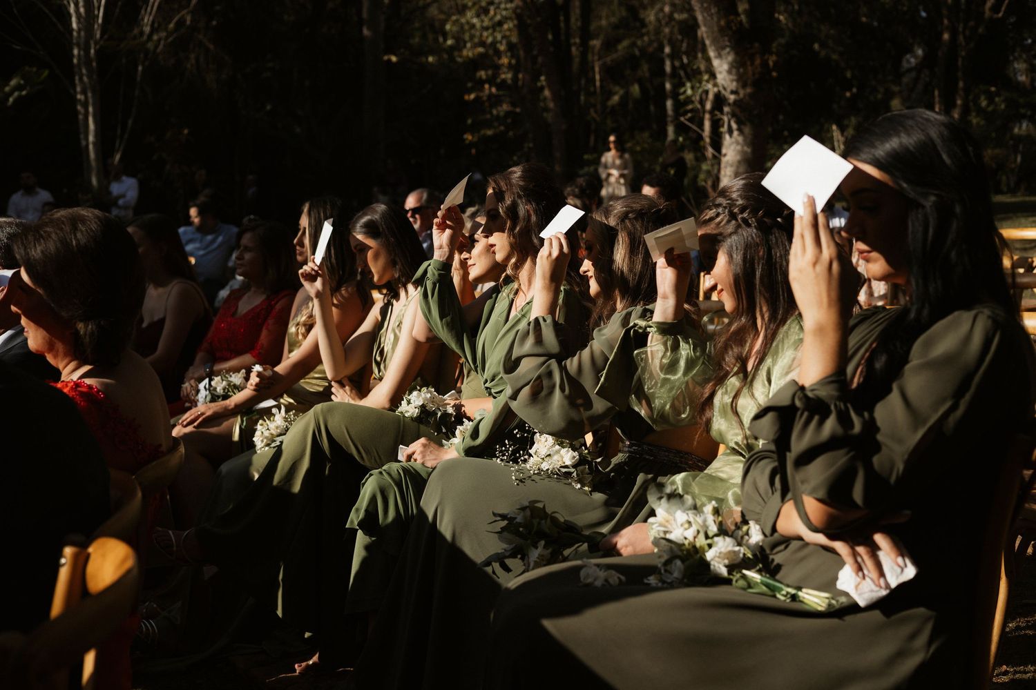 Wedding guests seated outdoors during golden hour ceremony.