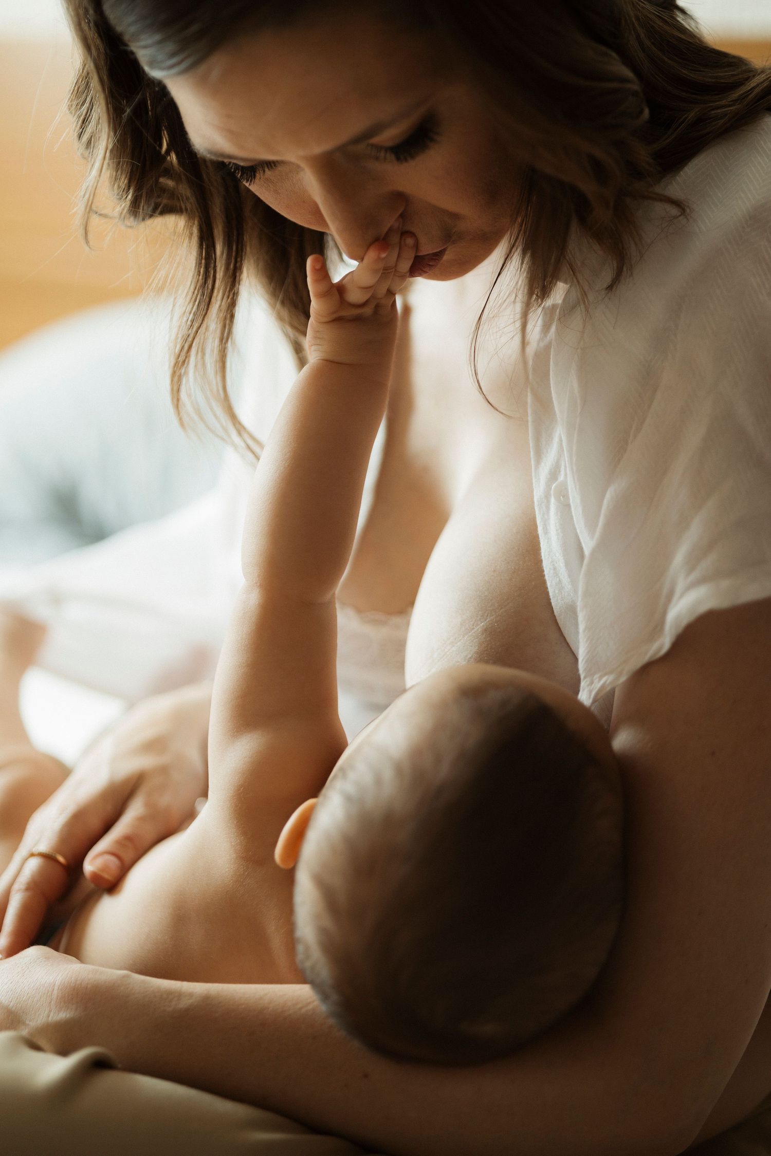Tender nurturing moment captured in soft golden light showing maternal care.