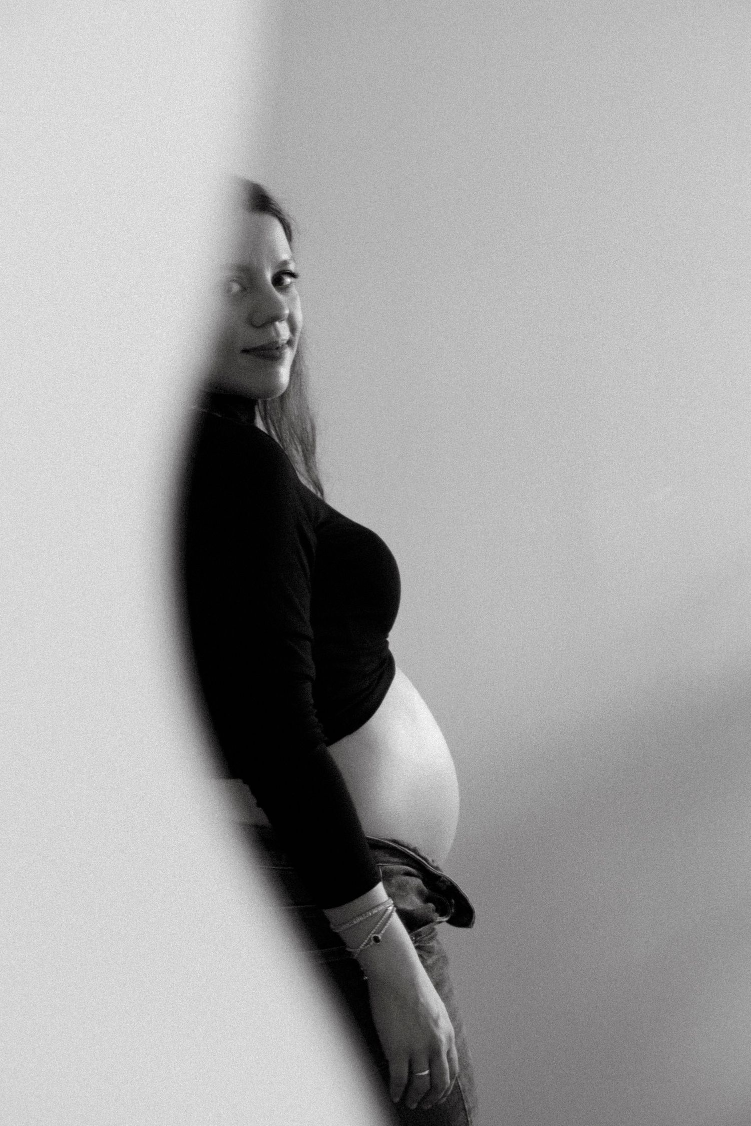 Artistic maternity photoshoot sequence showing silhouette against light background.