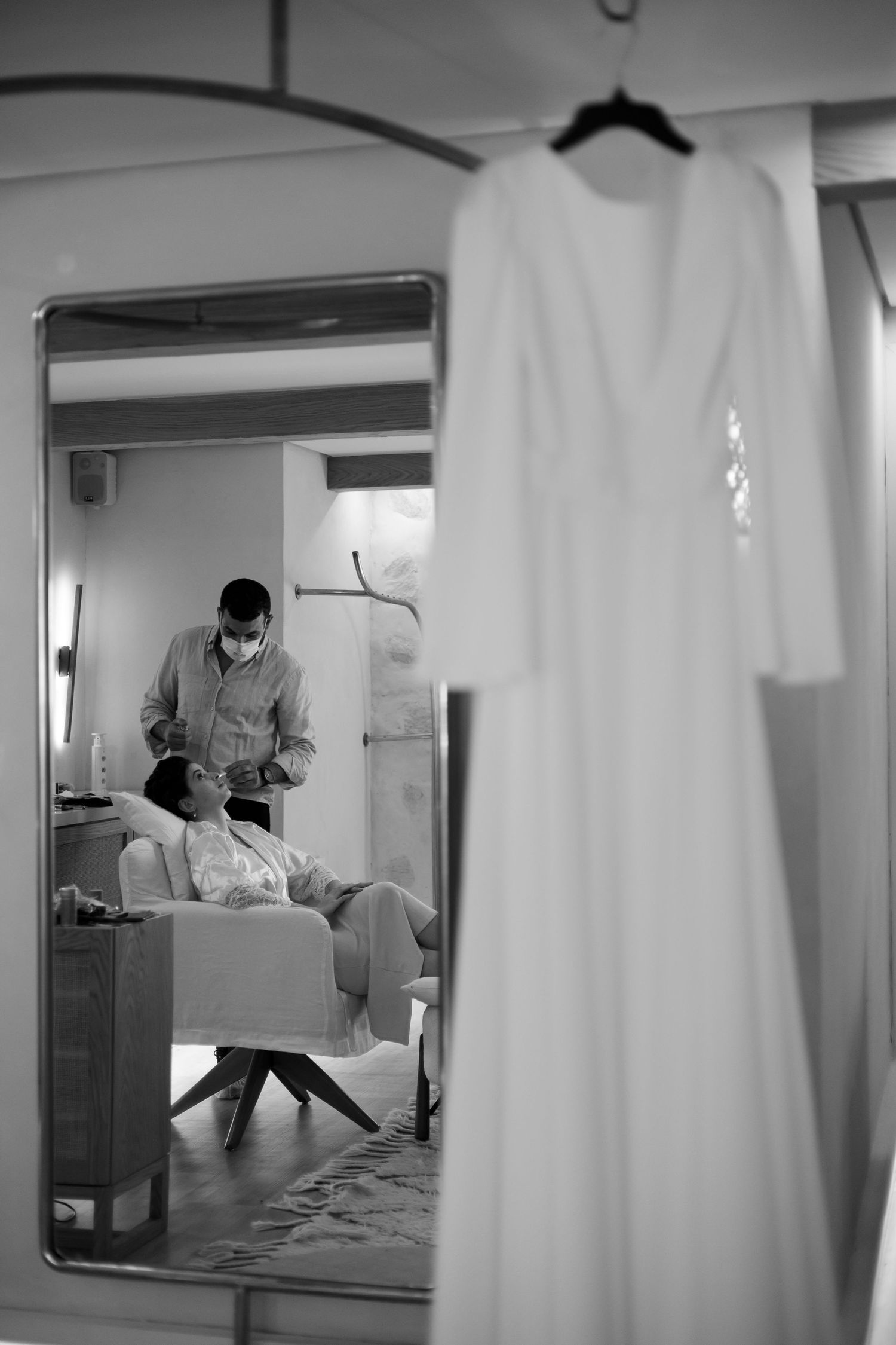Black and white interior scene with curtains and reflections in multiple mirrors.
