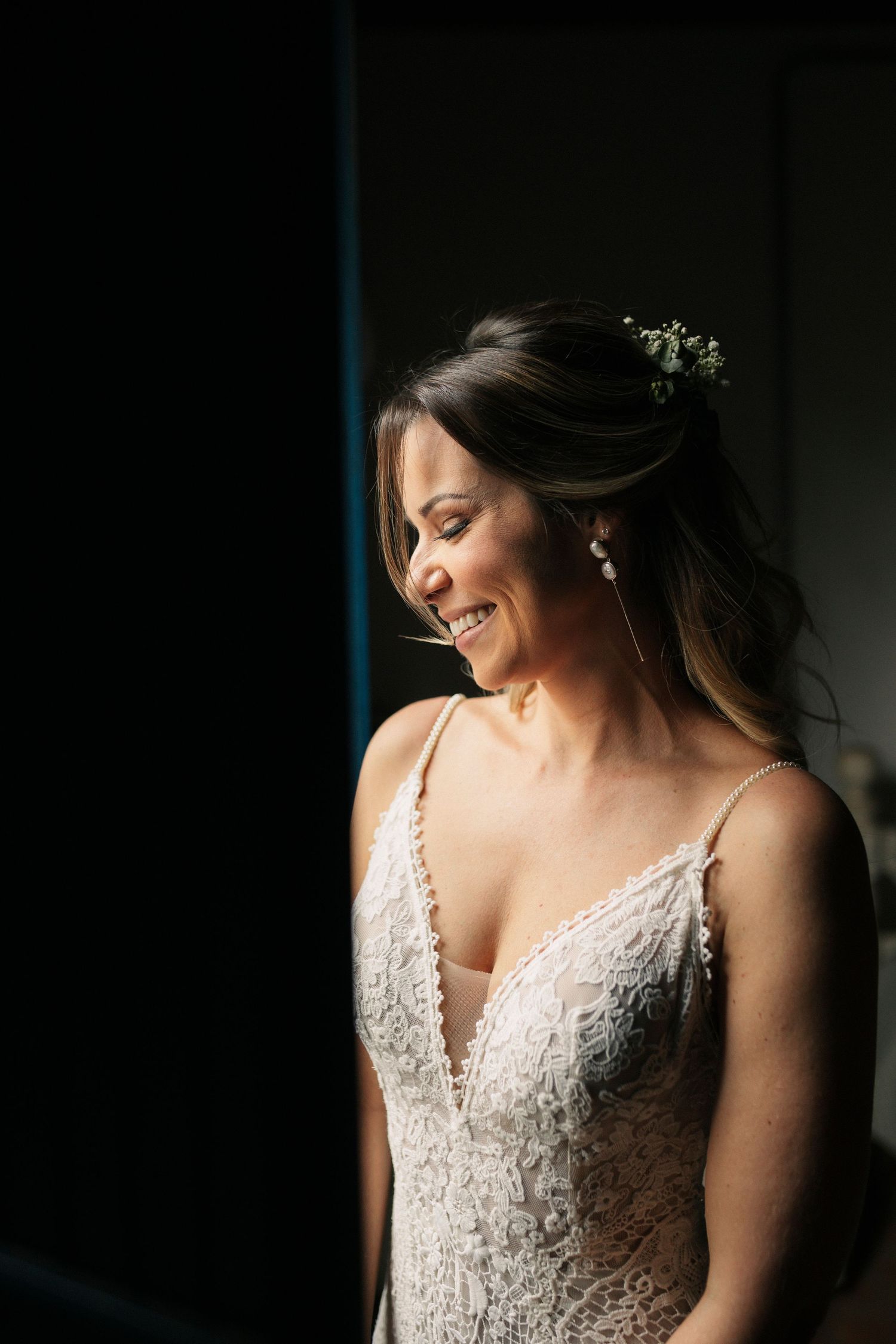 Artistic bridal portrait with dramatic side lighting highlighting lace details.