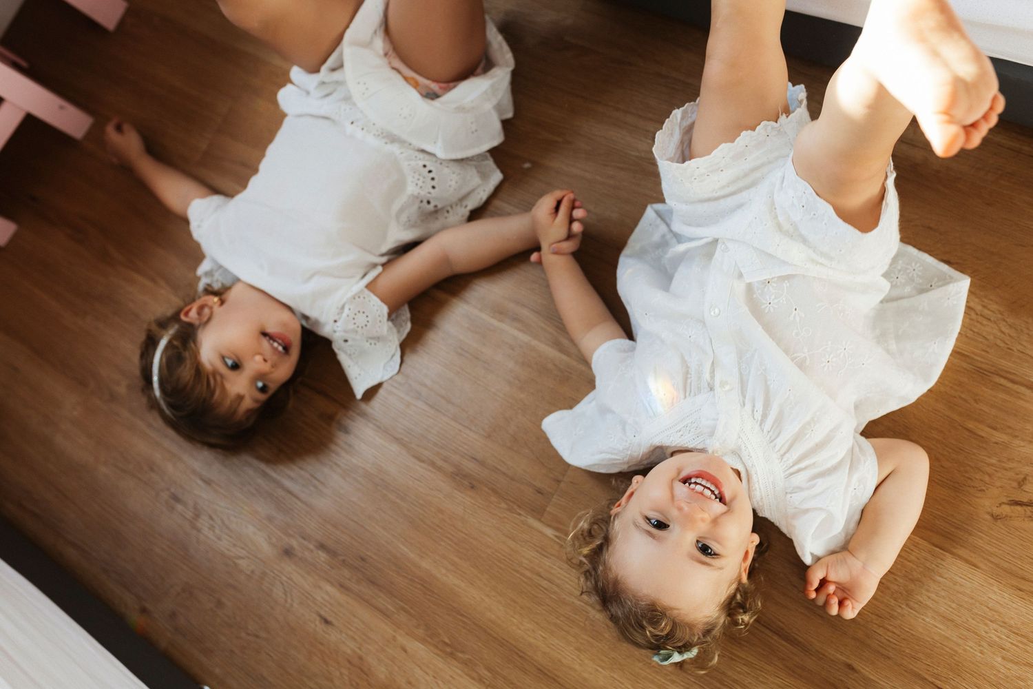 Series of playful poses on wooden floor in white clothing.