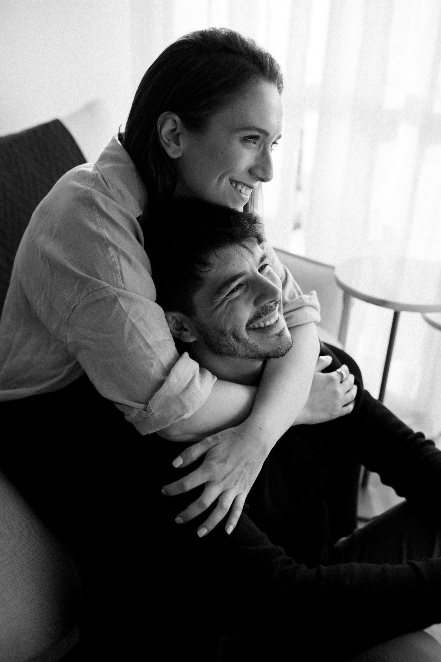 Black and white photographs of a couple embracing in an indoor setting.