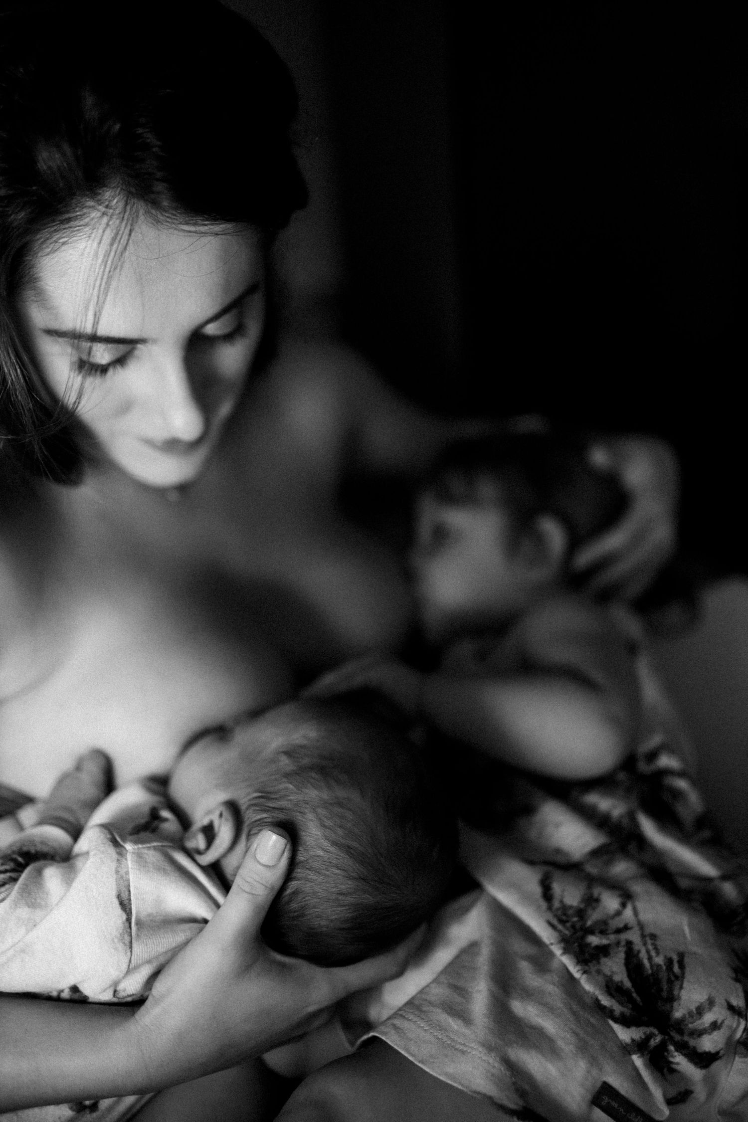 Intimate black and white portrait of mother and baby in tender embrace.